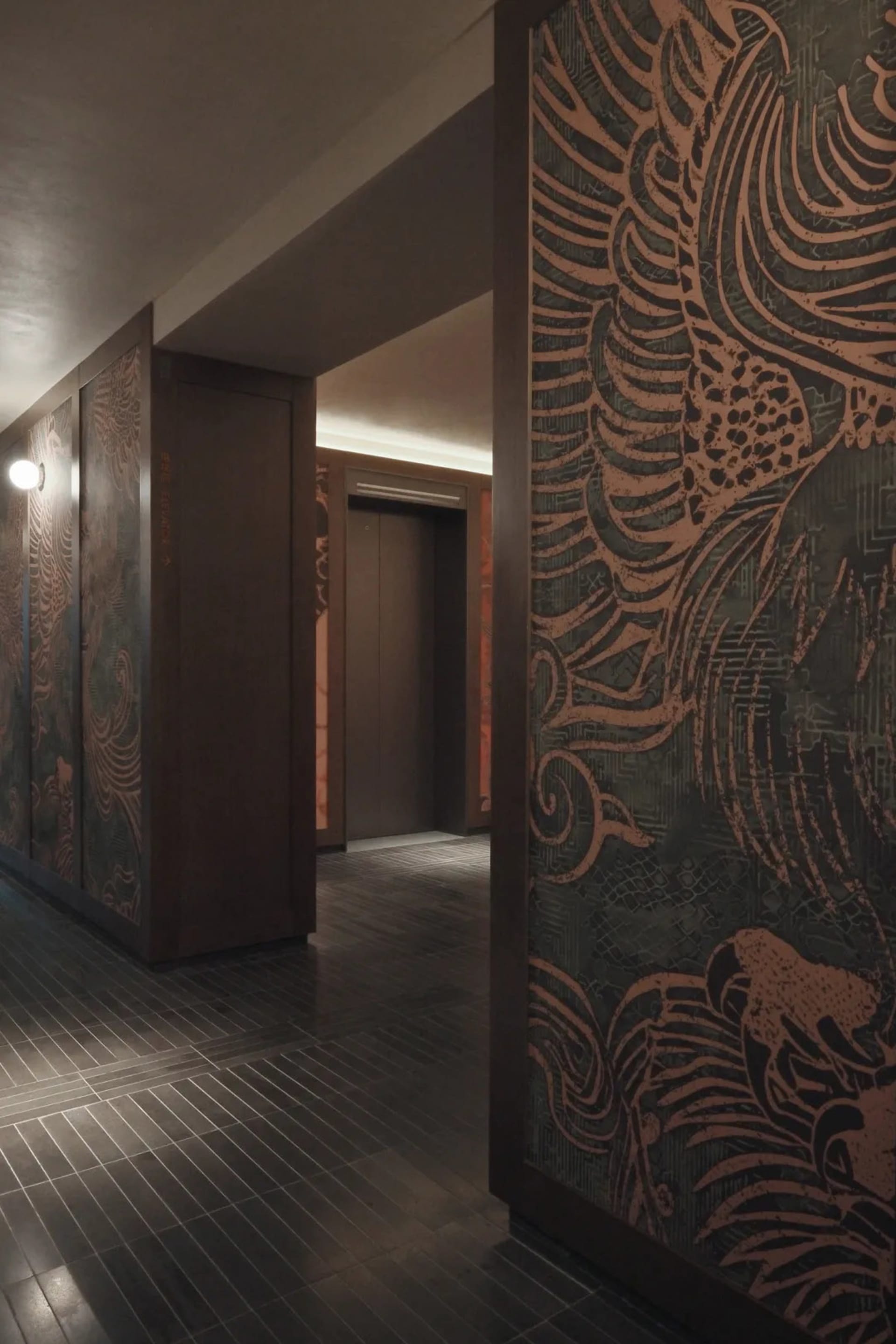 A dimly lit hallway with a wooden door featuring intricate design, set against a plain background