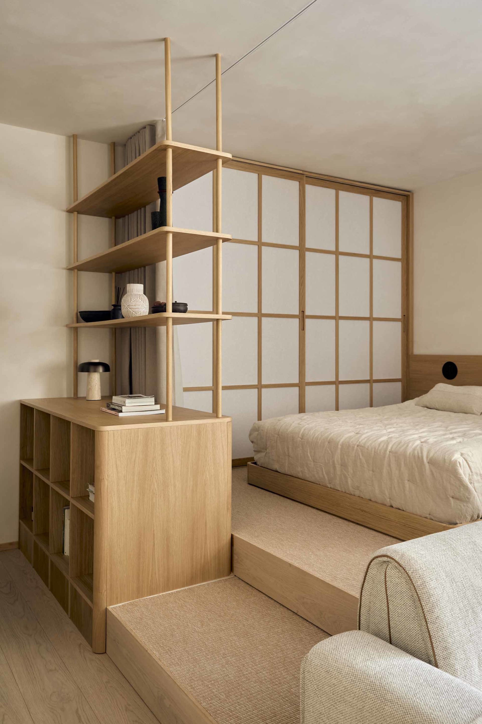 Cozy bedroom with a bed, bookshelf, and wooden floor, well-lit and inviting