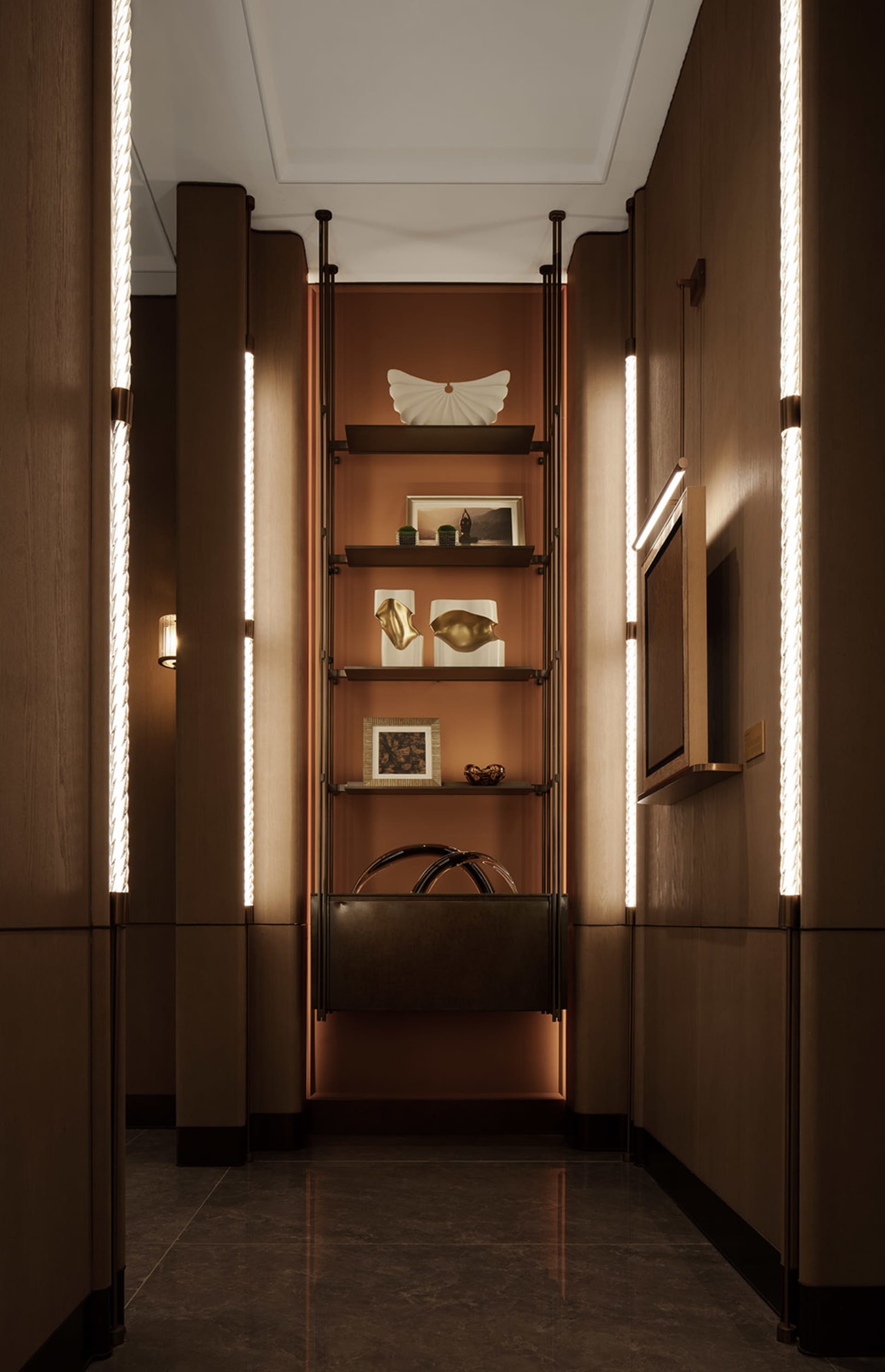 A modern hallway with a brown color scheme, featuring a shelf with a handbag and vase, and well-lit with a focus on functionality and organization