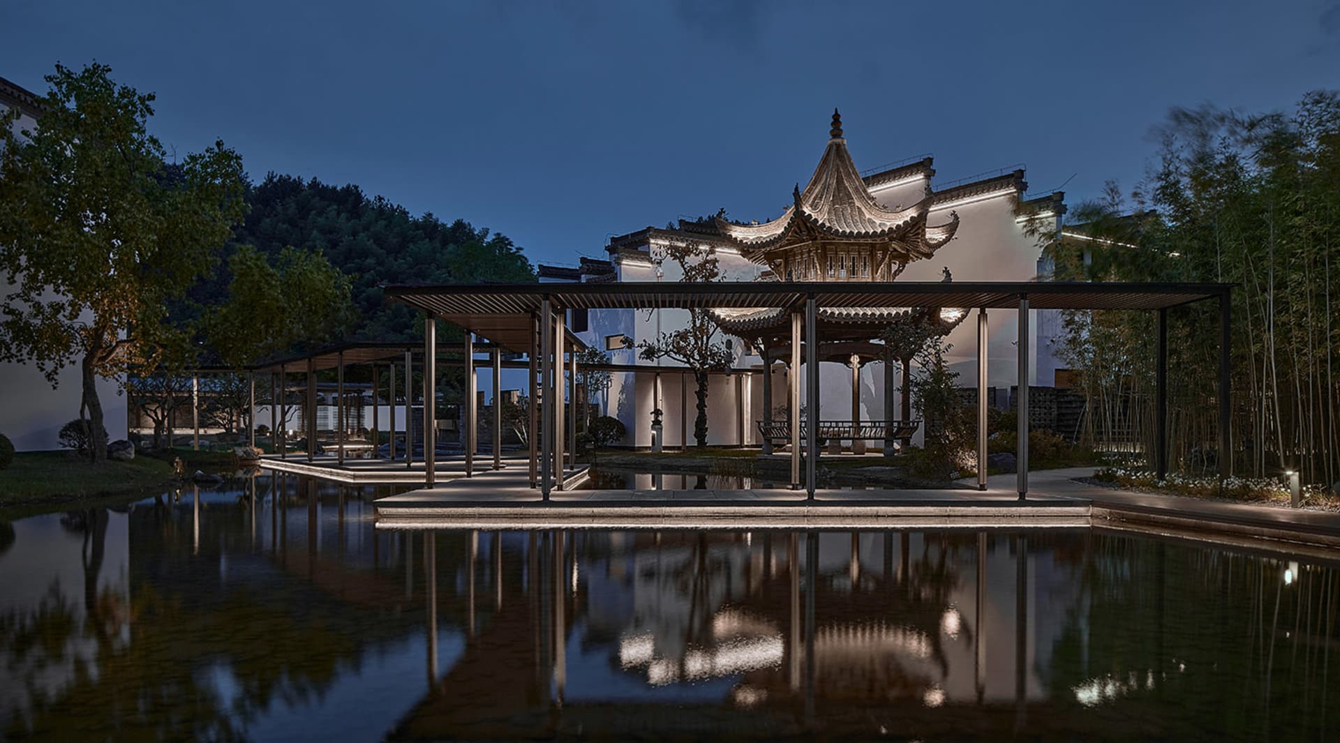 oriental-style building with a pagoda roof, water feature, and surrounding garden