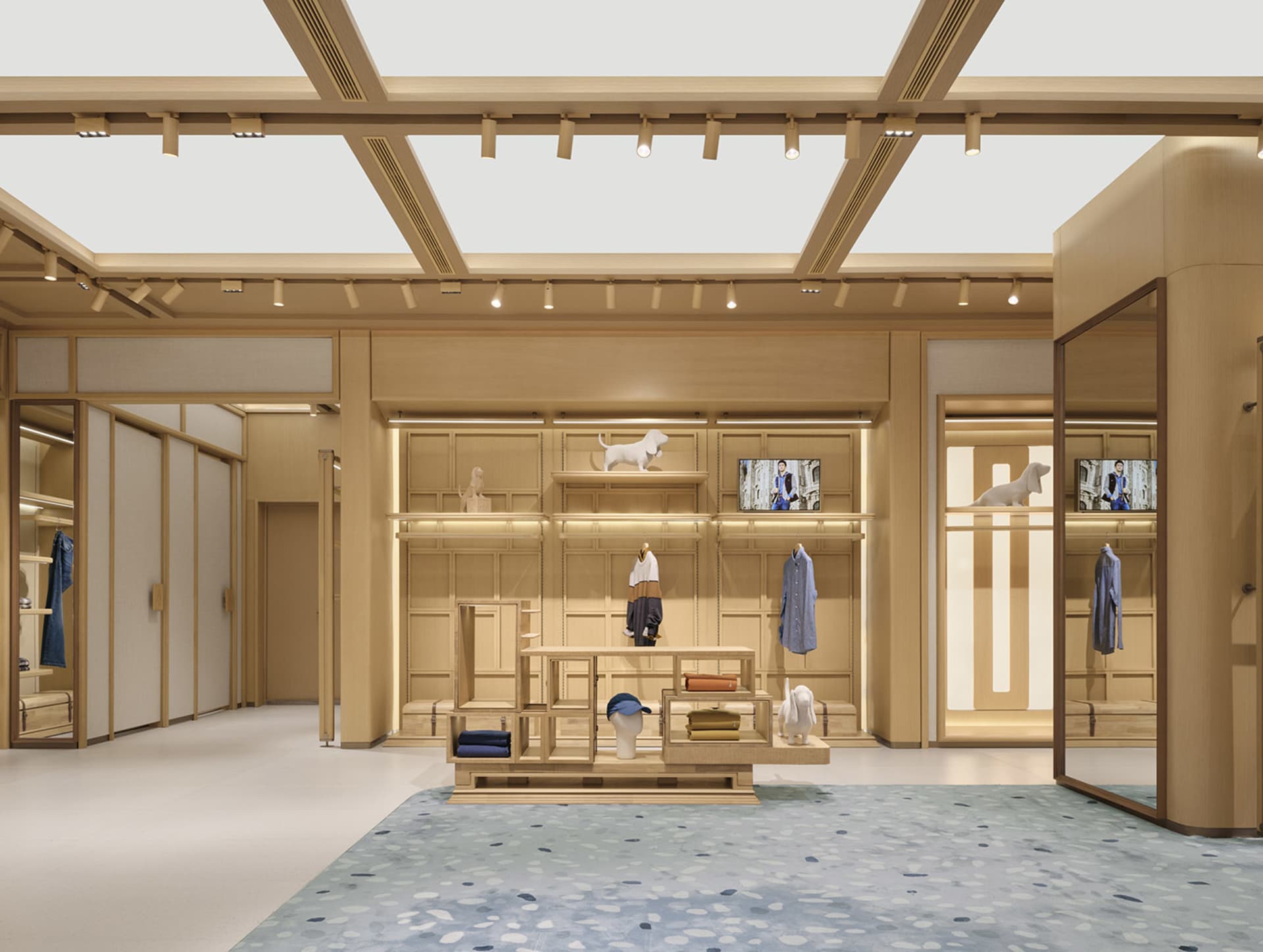 A well-lit retail store with wooden floors and walls, displaying shirts and ties on shelves and hanging on the walls