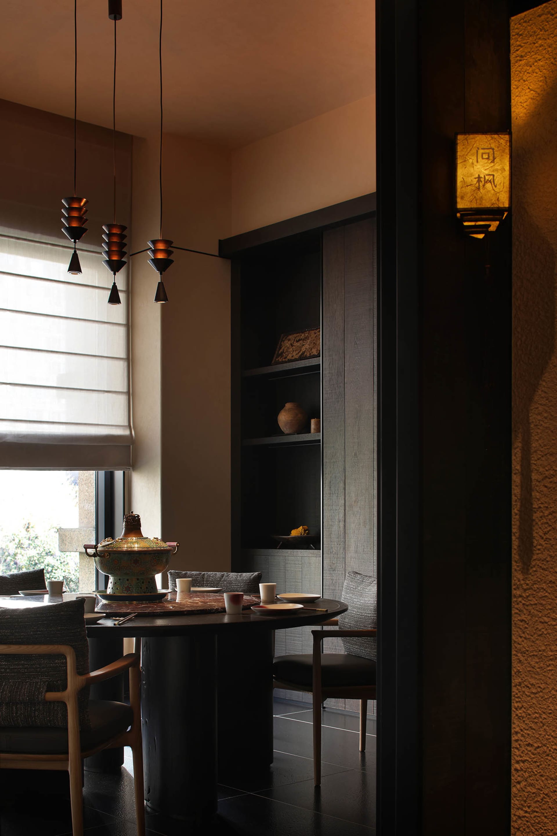 A well-lit dining room with a table set for a meal, featuring a vase, cups, and bowls, surrounded by comfortable furniture
