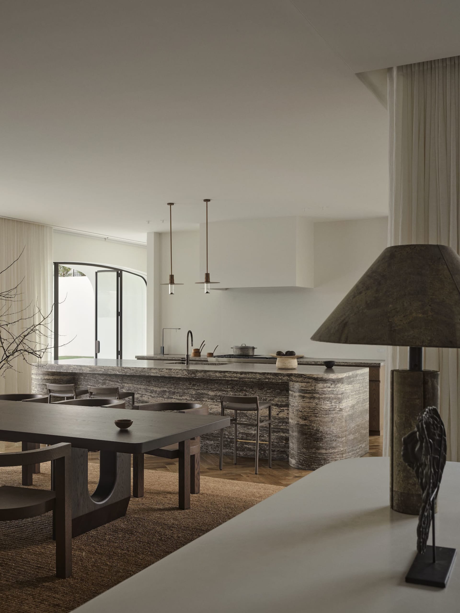 Modern kitchen with a marble countertop, center island, dining table, and well-lit space