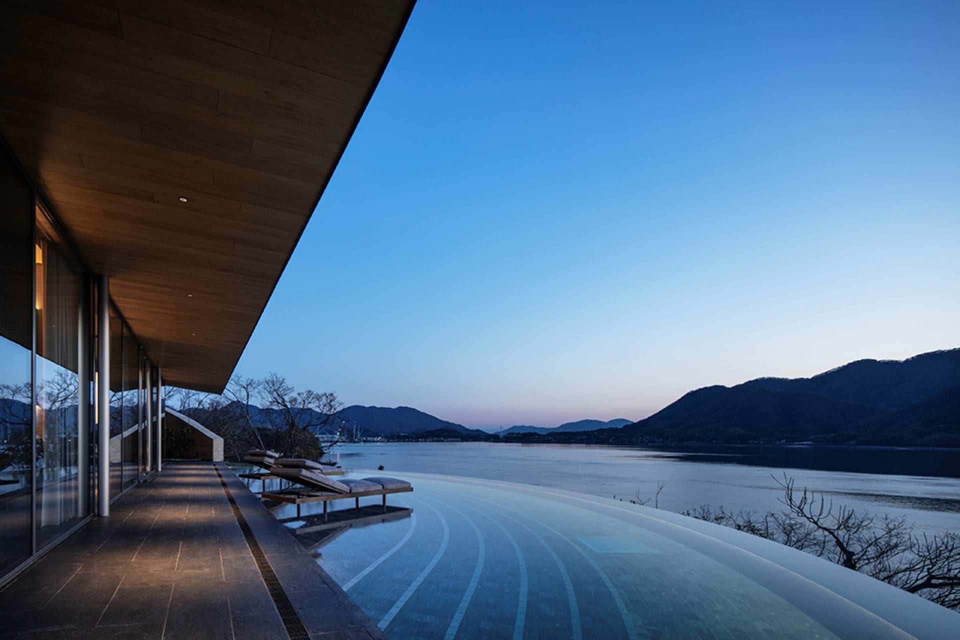 A serene pool scene with a wooden deck, a wooden building in the background, and a sense of relaxation