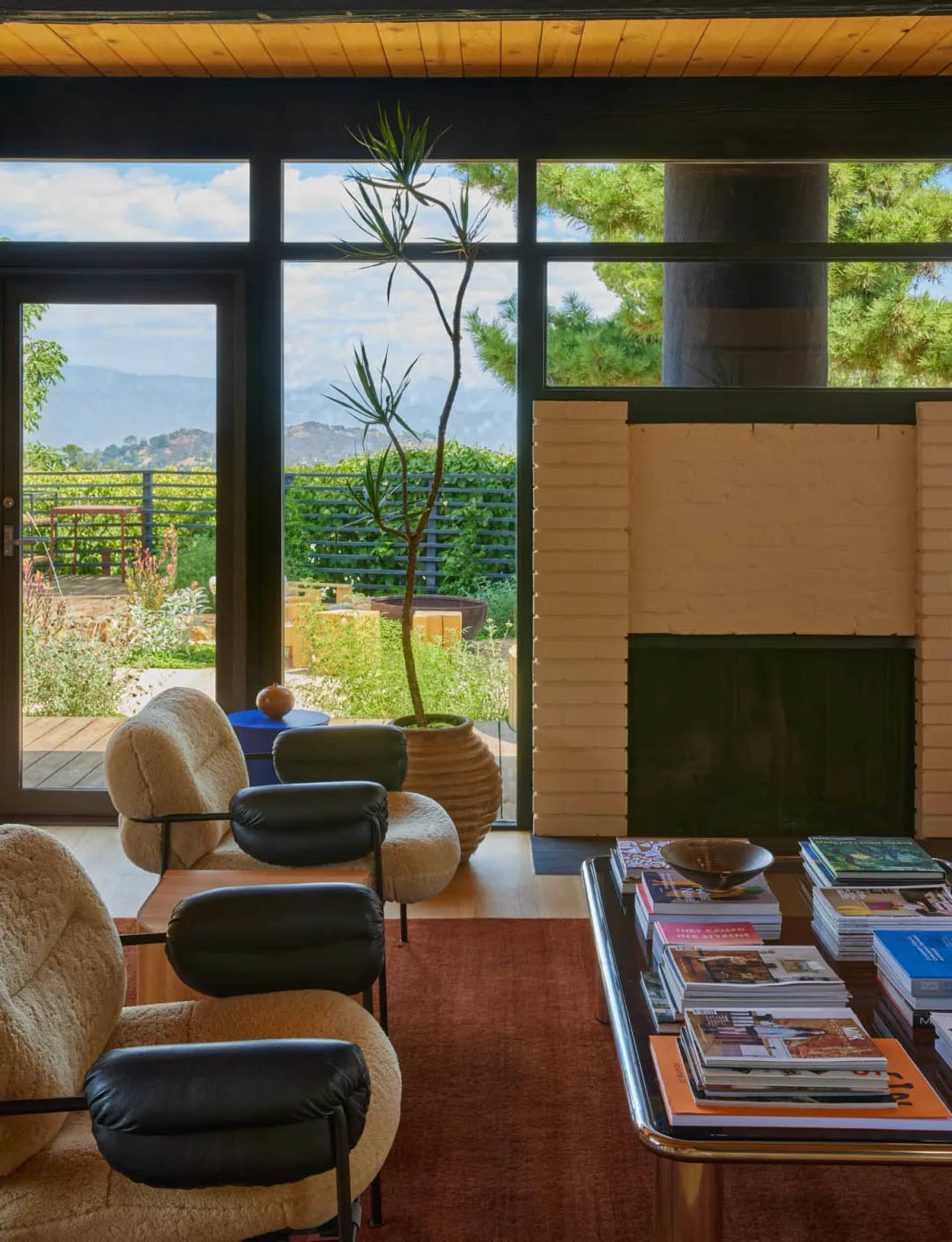 Cozy modern living space with a fireplace, large window, and wood furniture, featuring a warm and inviting atmosphere