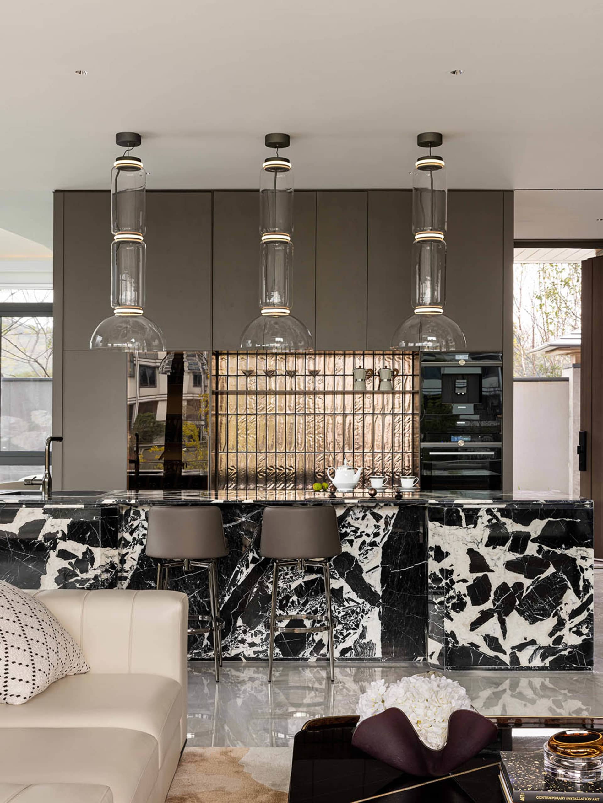 Modern kitchen with a marble countertop, center island, and dining table, featuring clean lines and minimalistic design