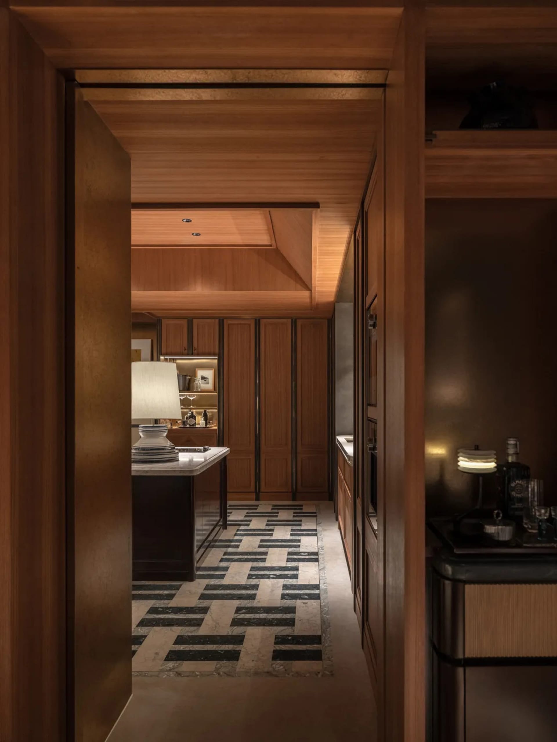 A well-lit kitchen dining area with a wooden door and a black and white checkered floor, featuring a dining table and a bowl