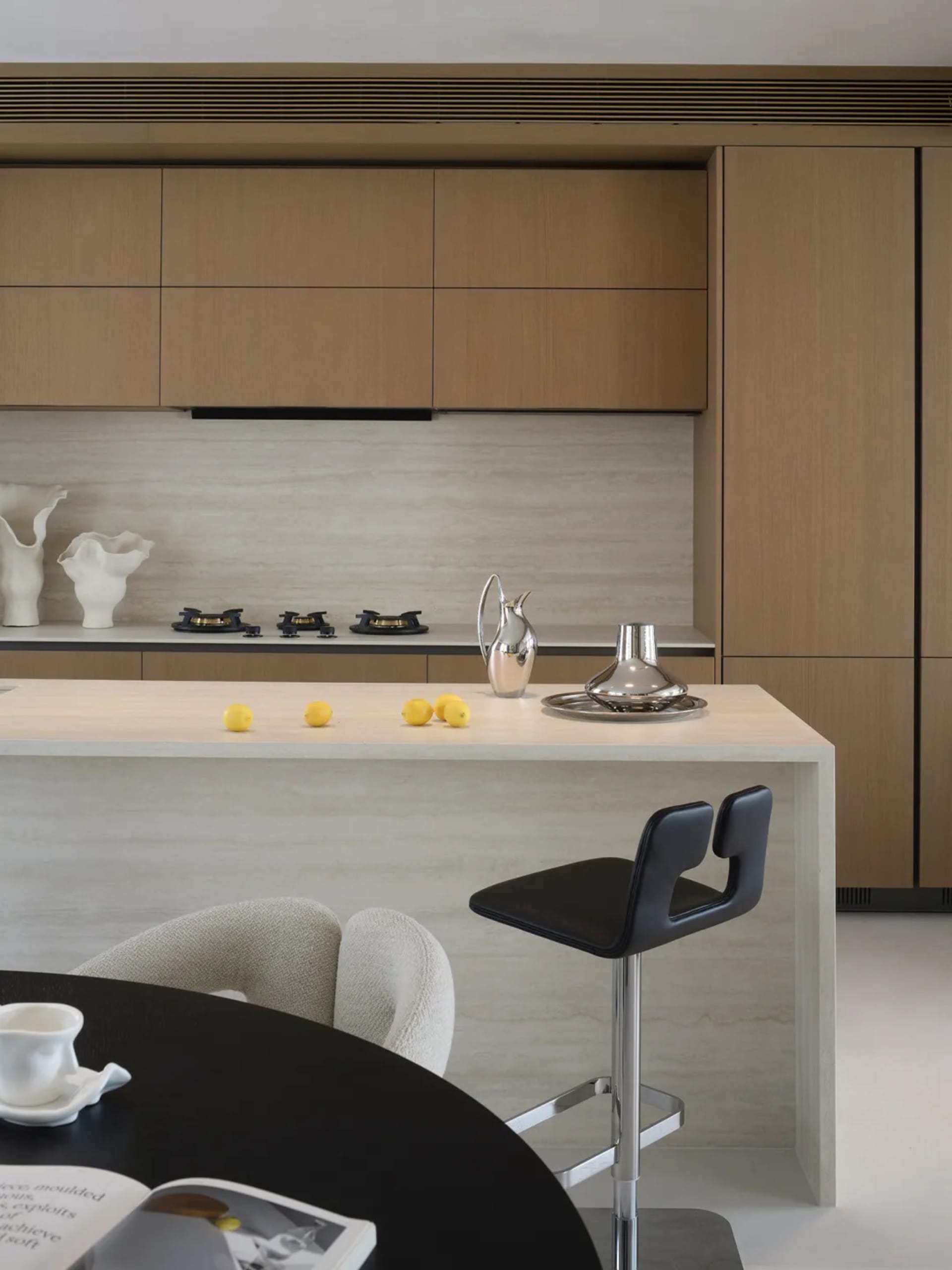 A modern kitchen with a white countertop, wooden cabinets, and a few decorative items, set in a bright and welcoming space