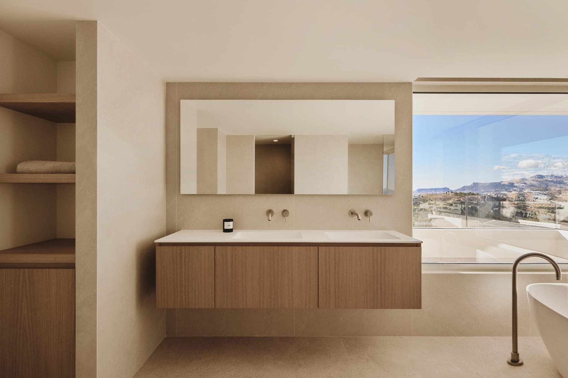 Clean modern bathroom with a wooden sink, large mirror, and natural light from a window