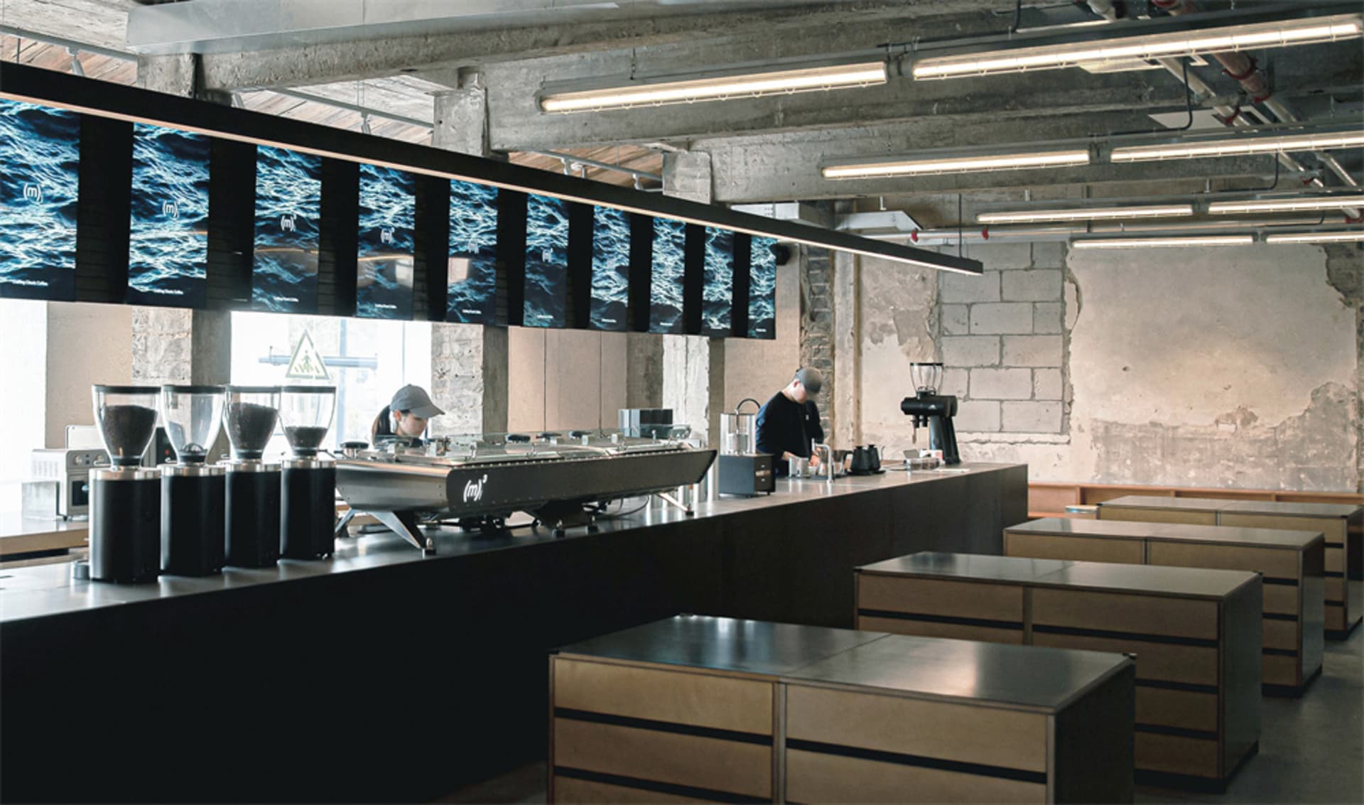 Sleek modern kitchen with wooden countertops, appliances, and a large island, lit by bright overhead lighting