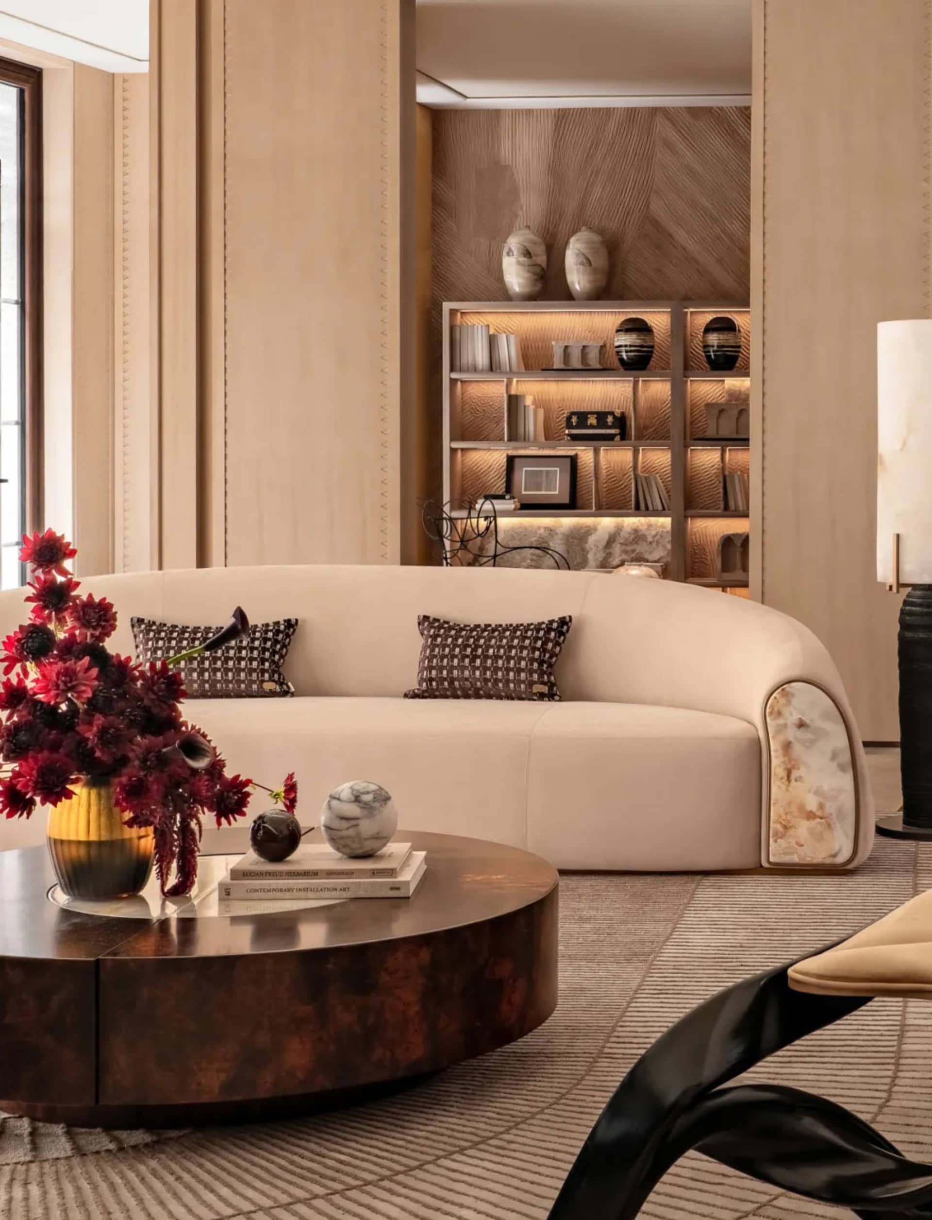 Comfortable living space with a large white couch, coffee table, fireplace, and decorative items, well-lit and inviting