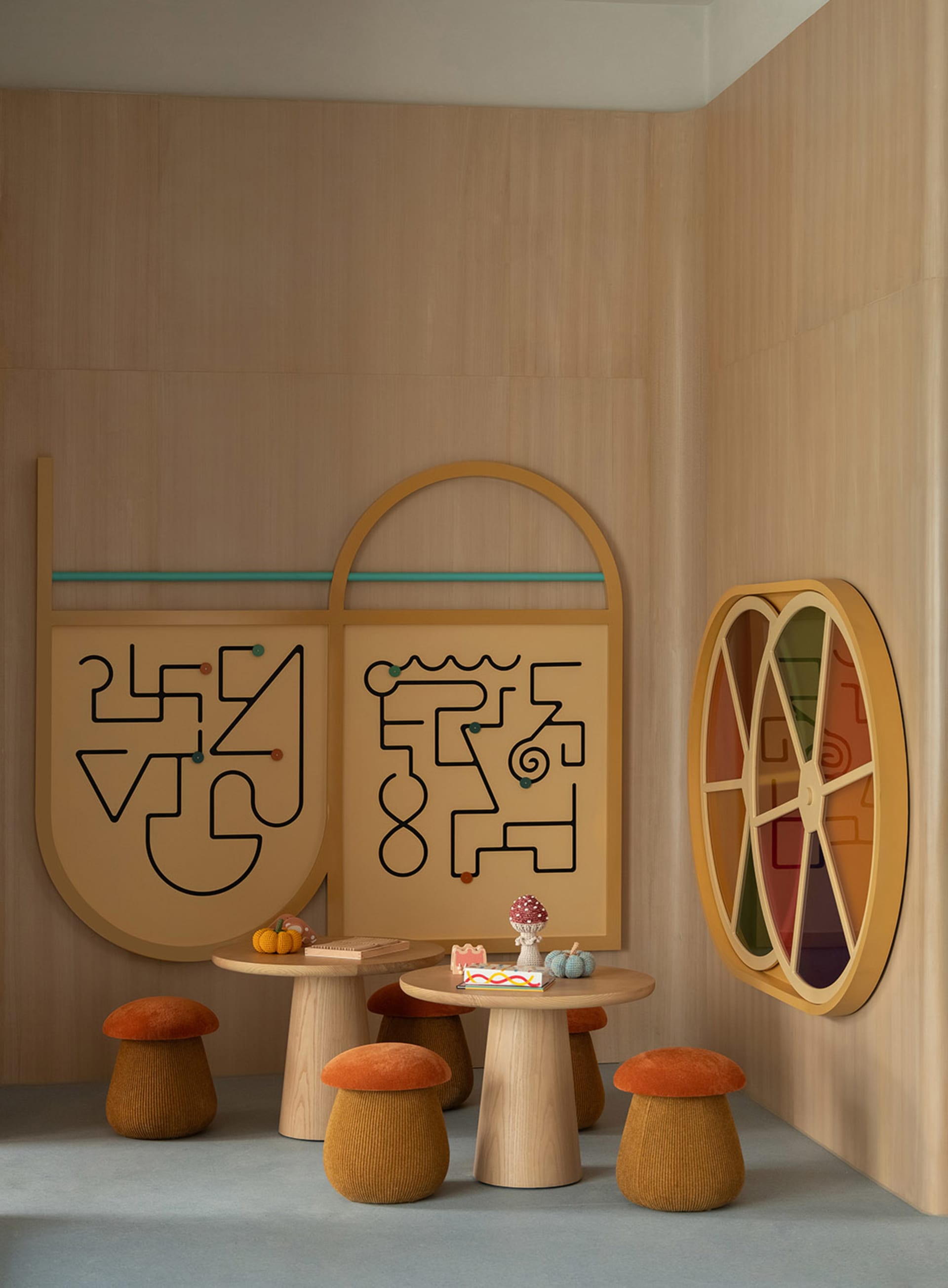 A modern dining room with a wooden table and chairs, set with a cake and oranges, and a mirror on the wall, with natural lighting
