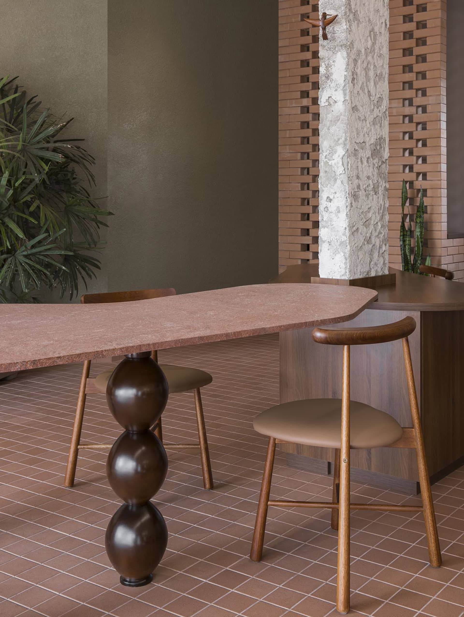 Dimly lit dining room with a brown table and chairs, a potted plant, and a cozy atmosphere