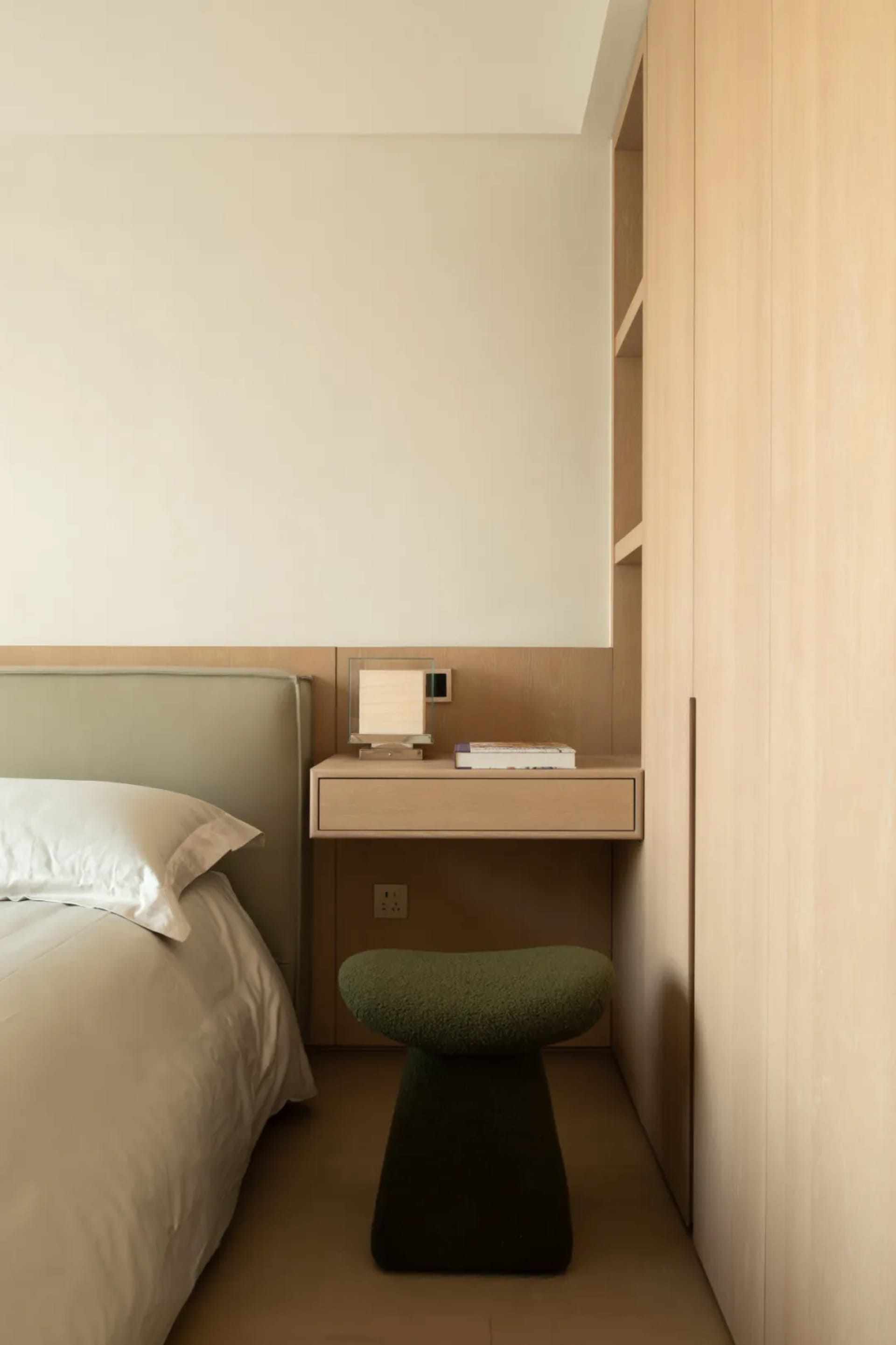Cozy bedroom with a bed, chair, and desk, featuring wooden furniture and a white color scheme, with soft and warm lighting
