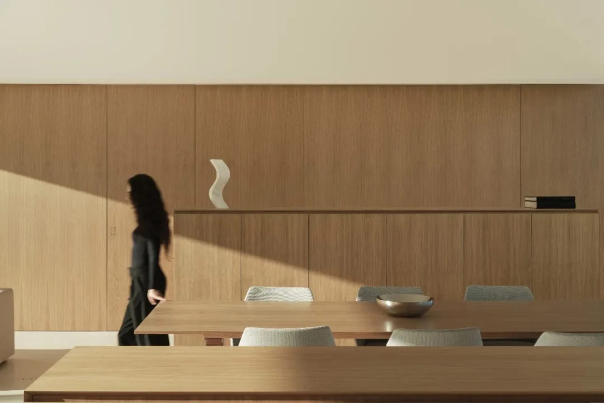 A well-lit dining room with a wooden table and chairs arranged in a semi-circle, creating a warm and inviting atmosphere