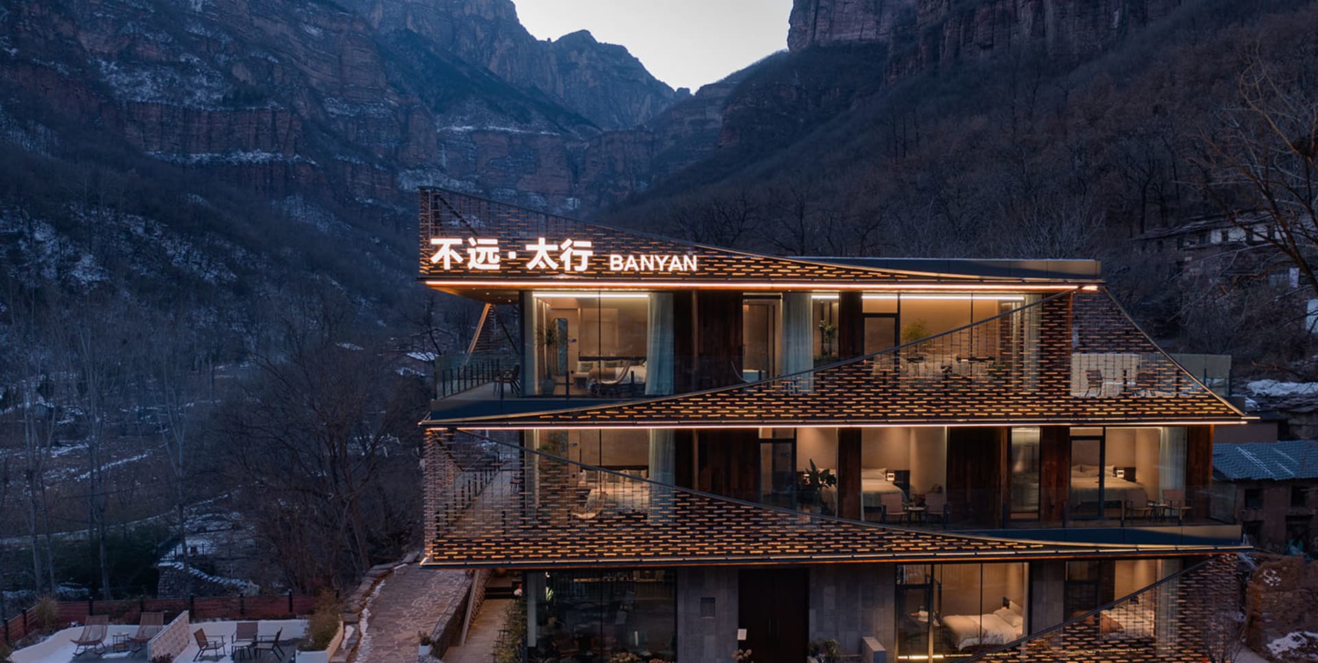 現代建築，外牆以水泥為主，經過調暗照明，建築側面附有大型廣告牌 