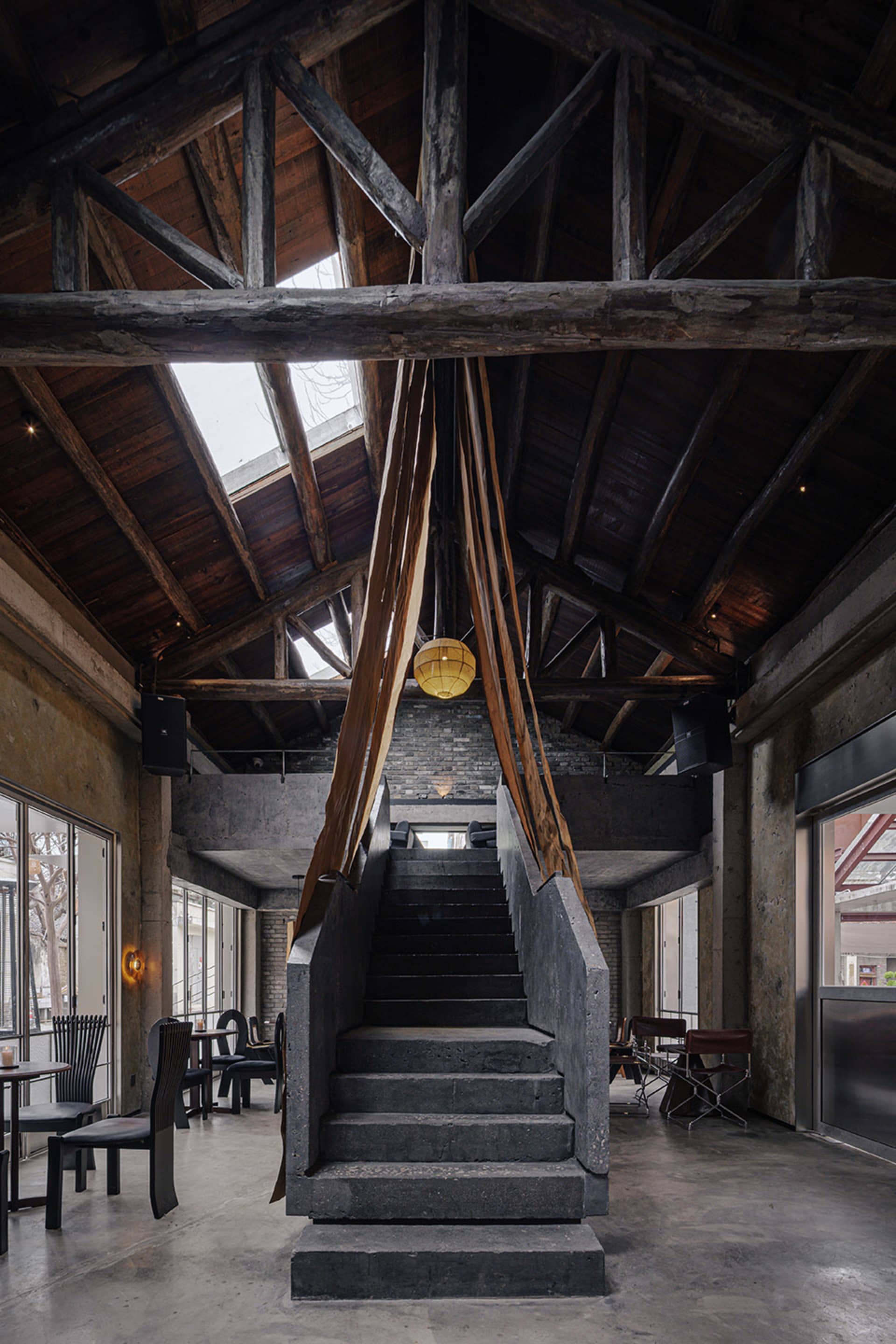 Cozy dining space with a wooden railing, stone wall, and natural light, featuring a modern and functional design