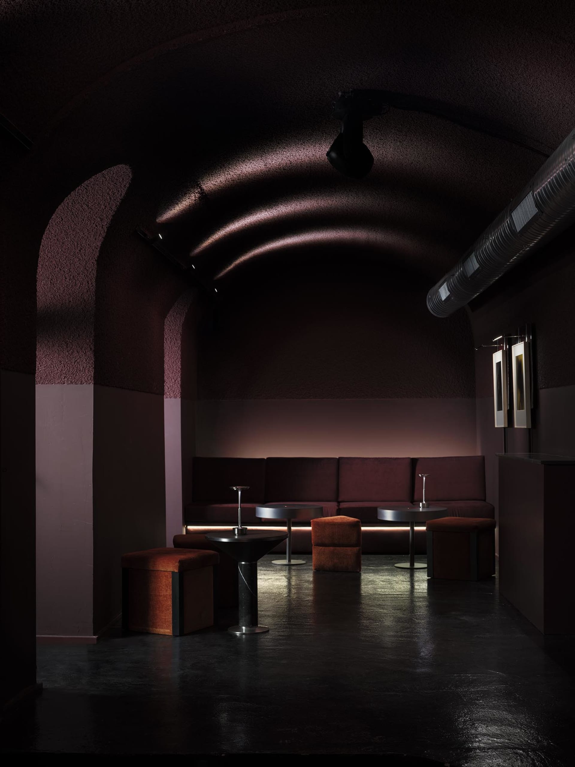 Cozy dining room with a purple wall, red ceiling, wooden walls, and a dining table, bar counter, and couches