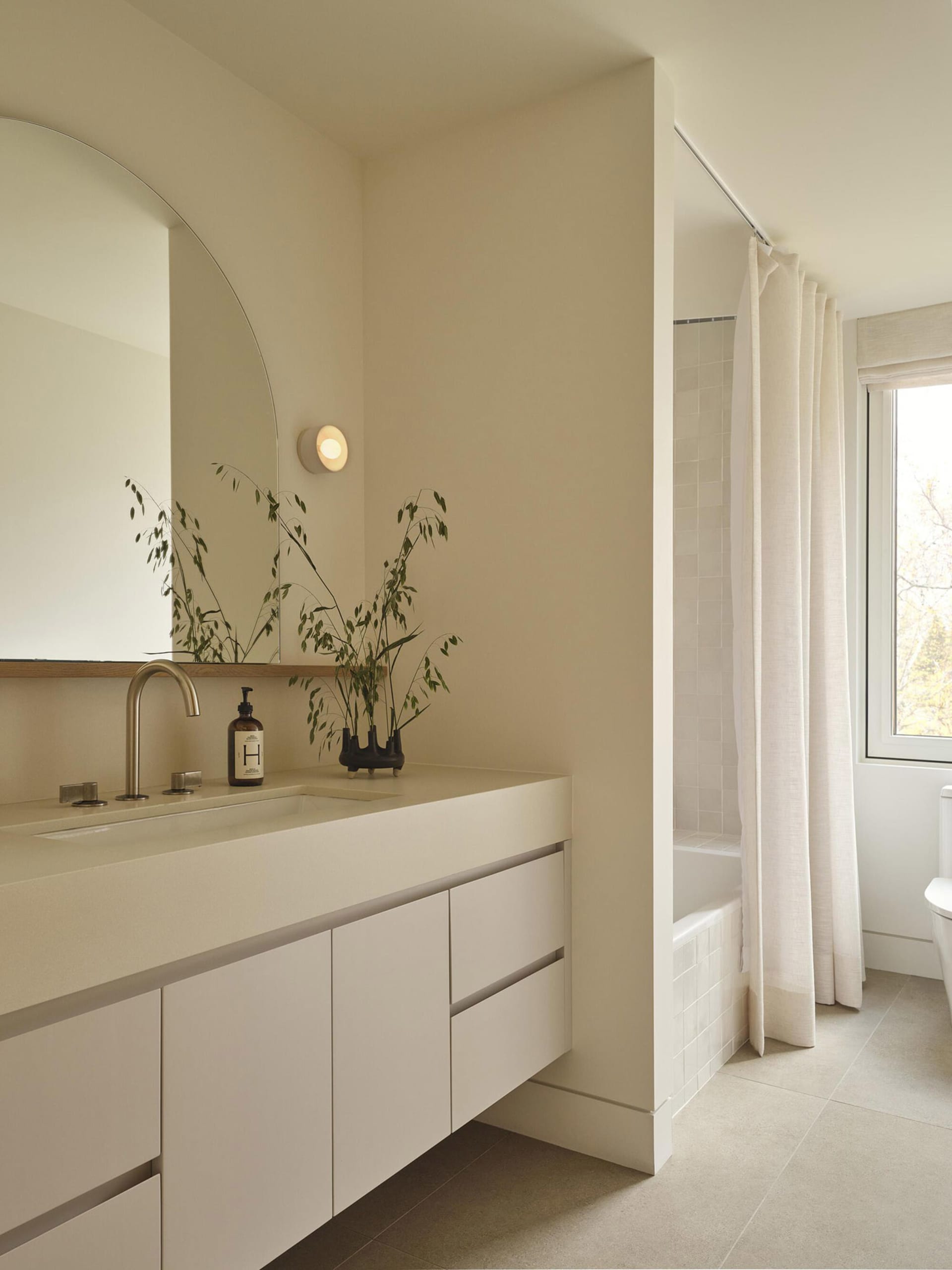 A modern bathroom with a white sink, toilet, and bathtub, set against a white background with a mirror above the sink