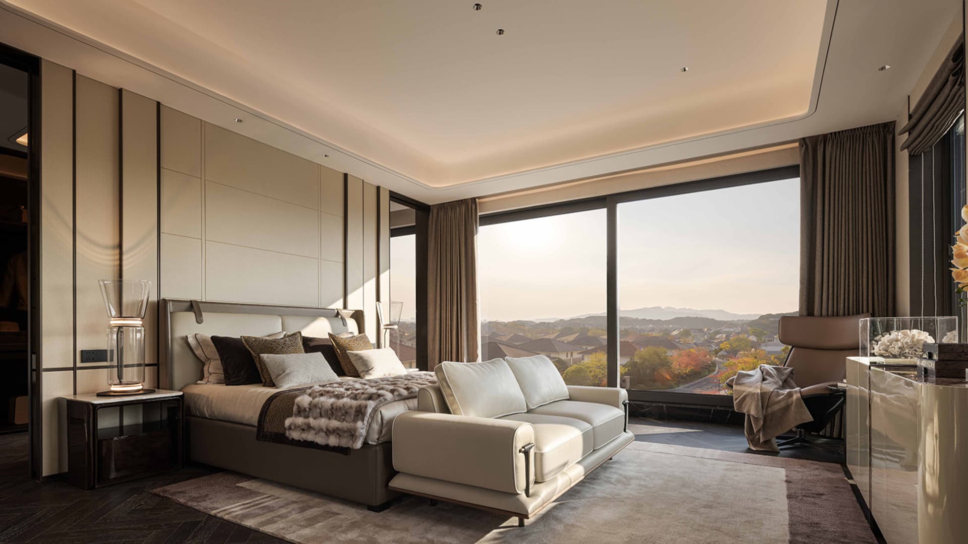 Cozy bedroom with a tan color scheme, a large window, and a comfortable bed and couch arrangement