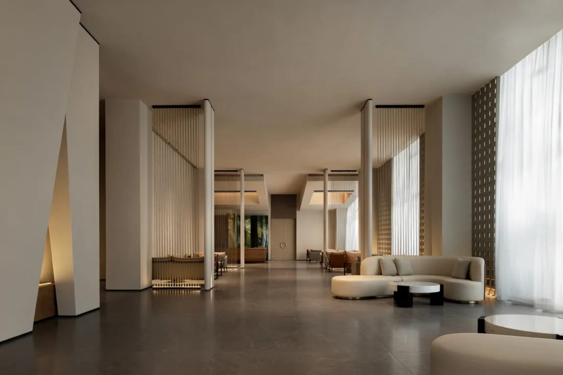 A modern living room with a large couch, chair, and dining table, featuring white walls, a wooden floor, and a glass table, with natural light coming in through the windows