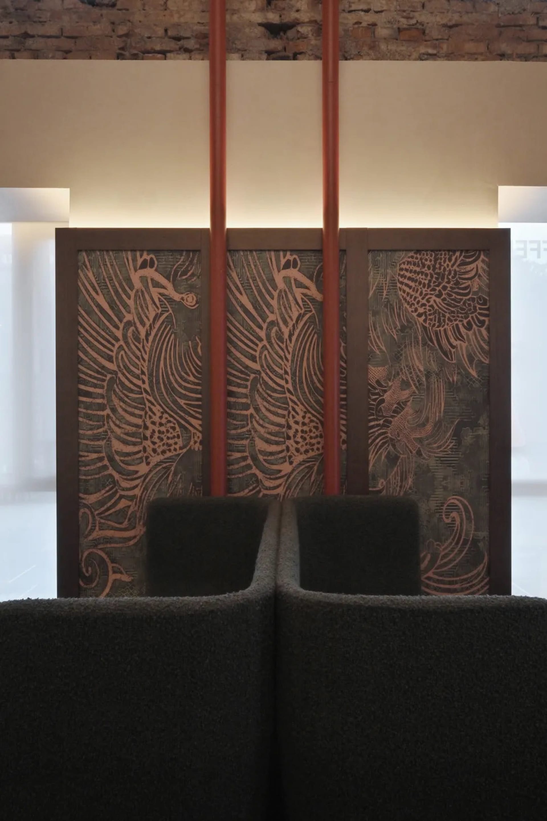 A waiting area with a wooden wall and a large bird painting, two chairs facing the painting, creating a warm and inviting space with a sense of elegance and sophistication
