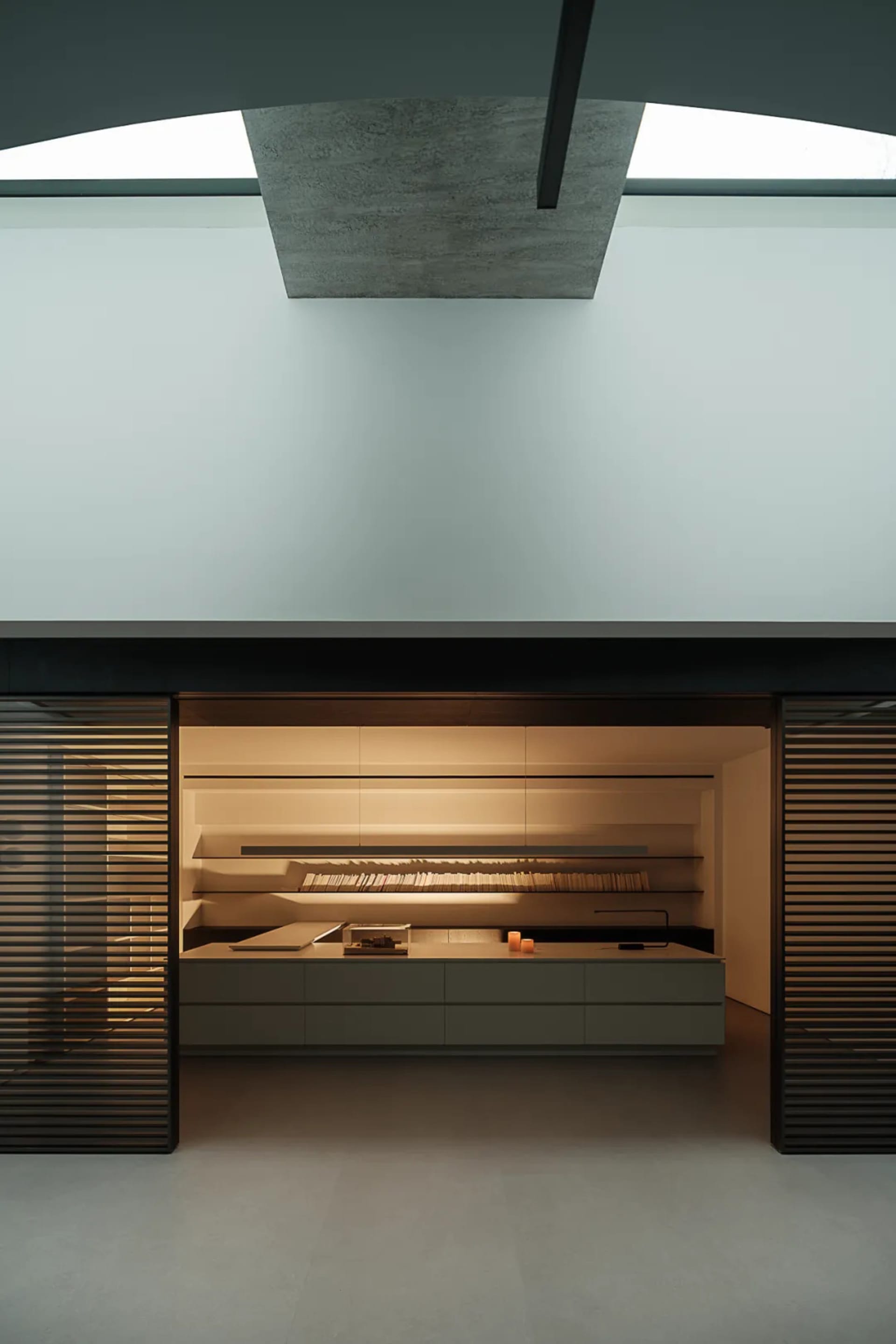 Cozy modern kitchen with a white wall, large window, sink, refrigerator, and modern art piece