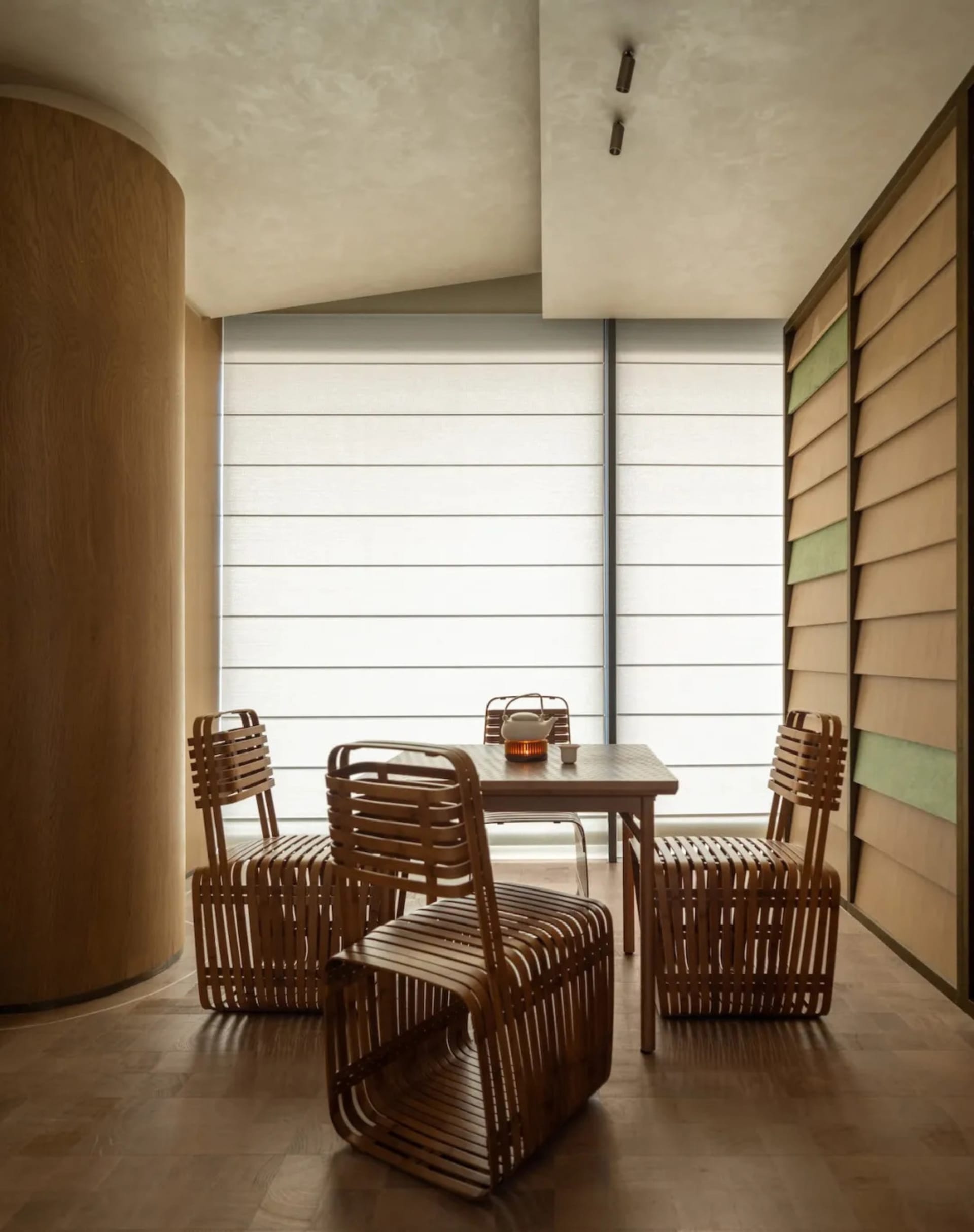 Cozy dining room with a wooden floor, a wicker and wood table, and dim lighting