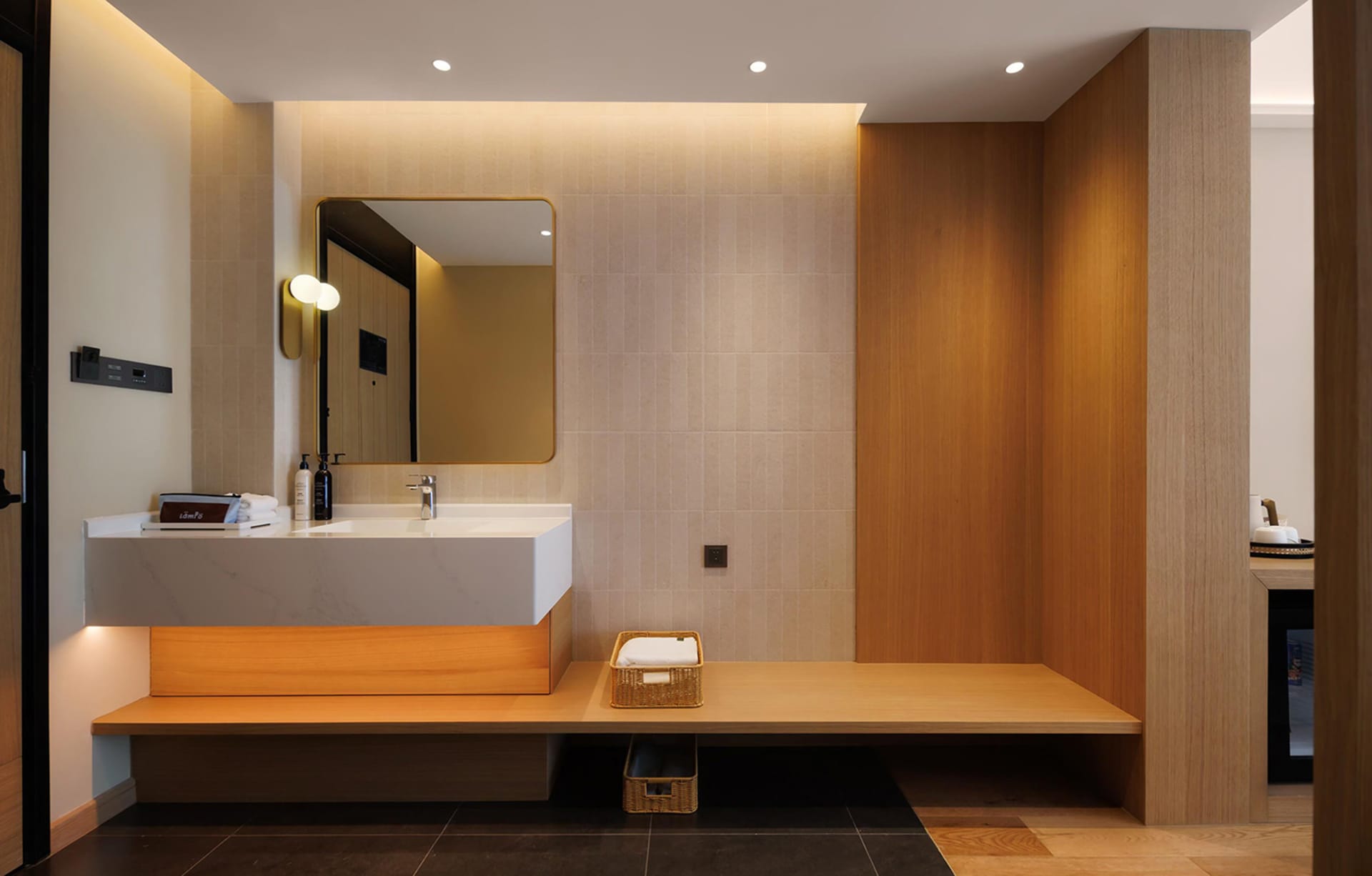 Bathroom with a white sink, wooden walls, and a mirror above the sink in a dimly lit space