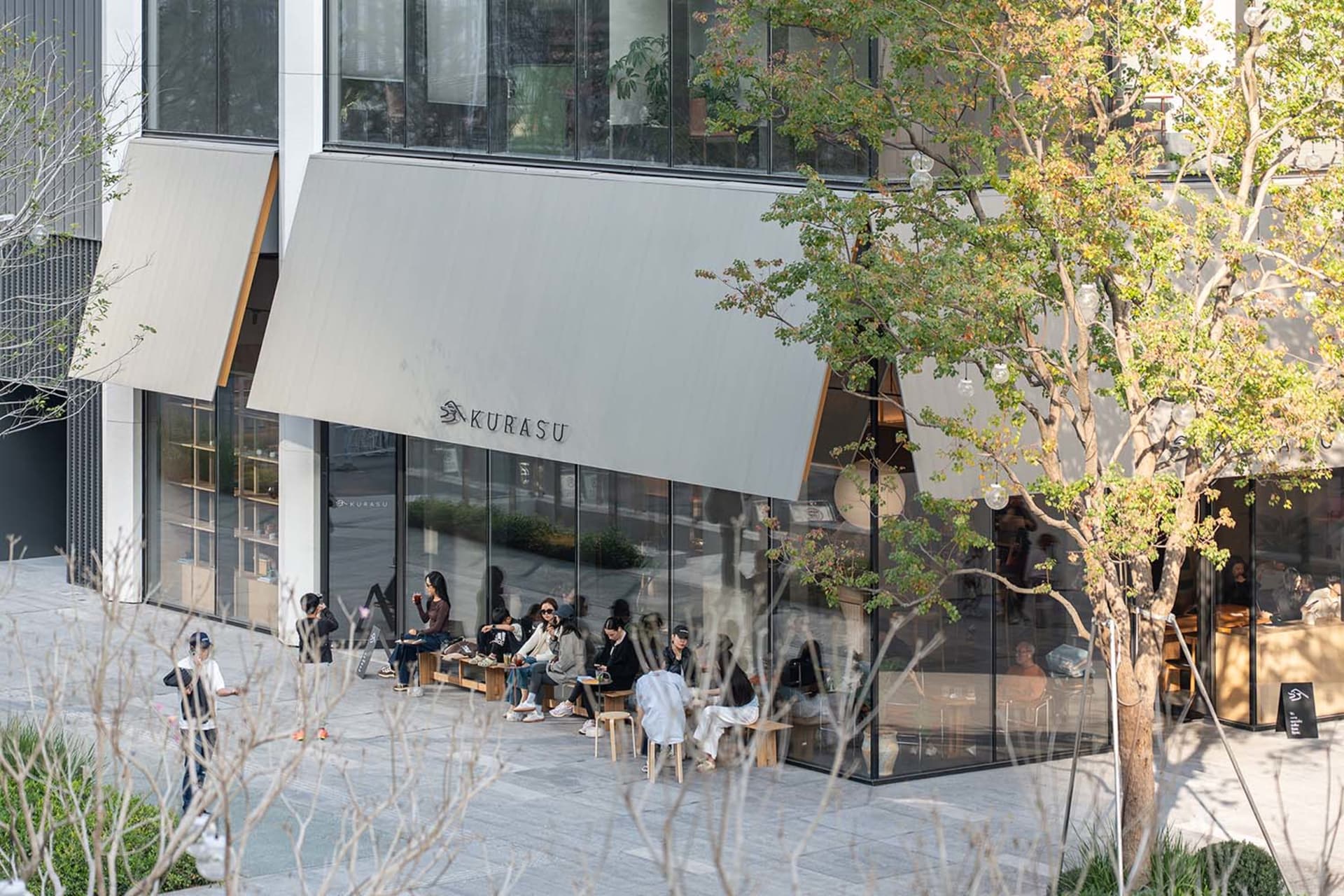 一間休閒的市區餐廳，客人坐在桌子上，自然光線照射於場景