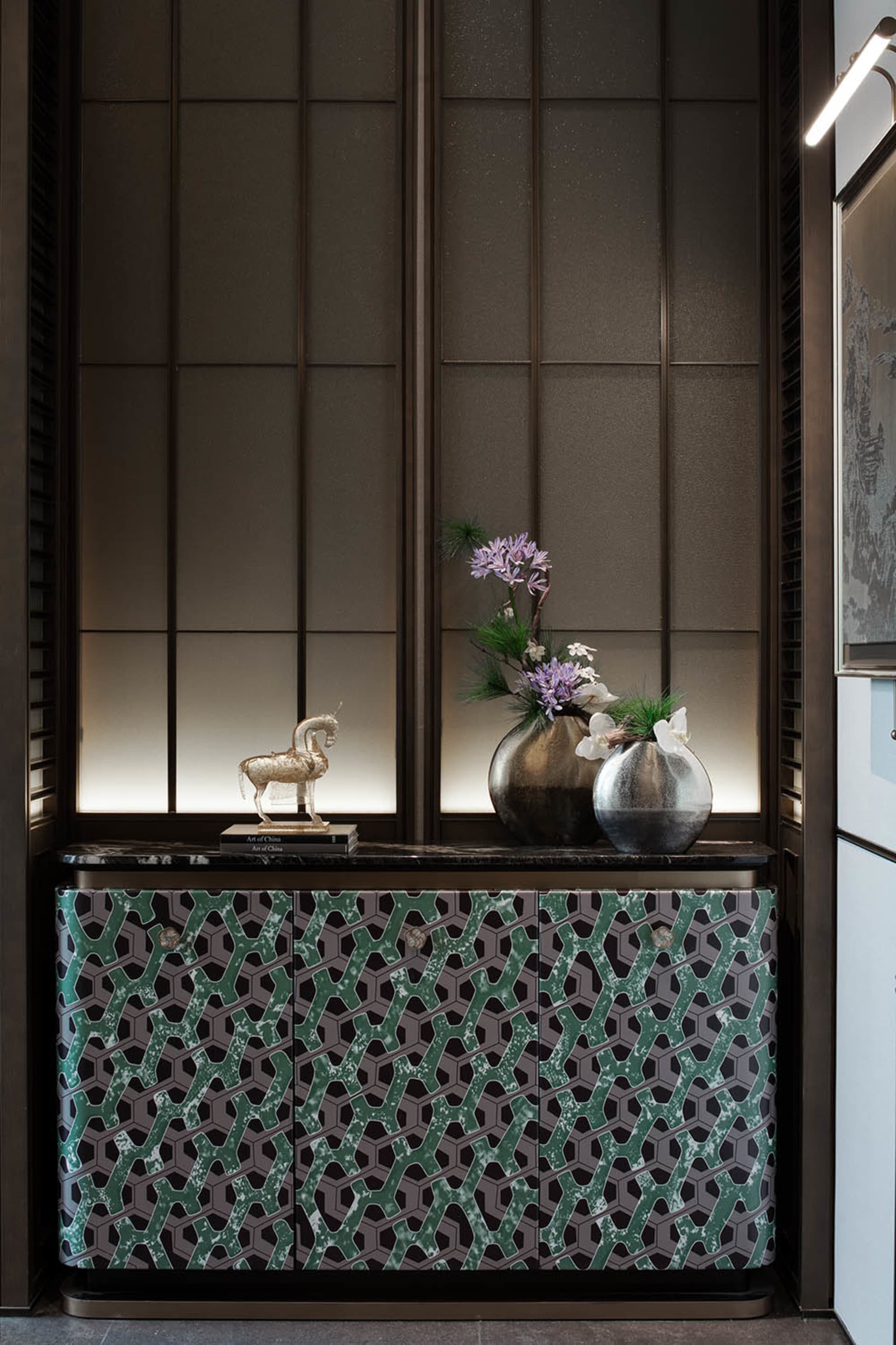 Warm and inviting room with a wooden cabinet, a vase of flowers, and natural light from a window