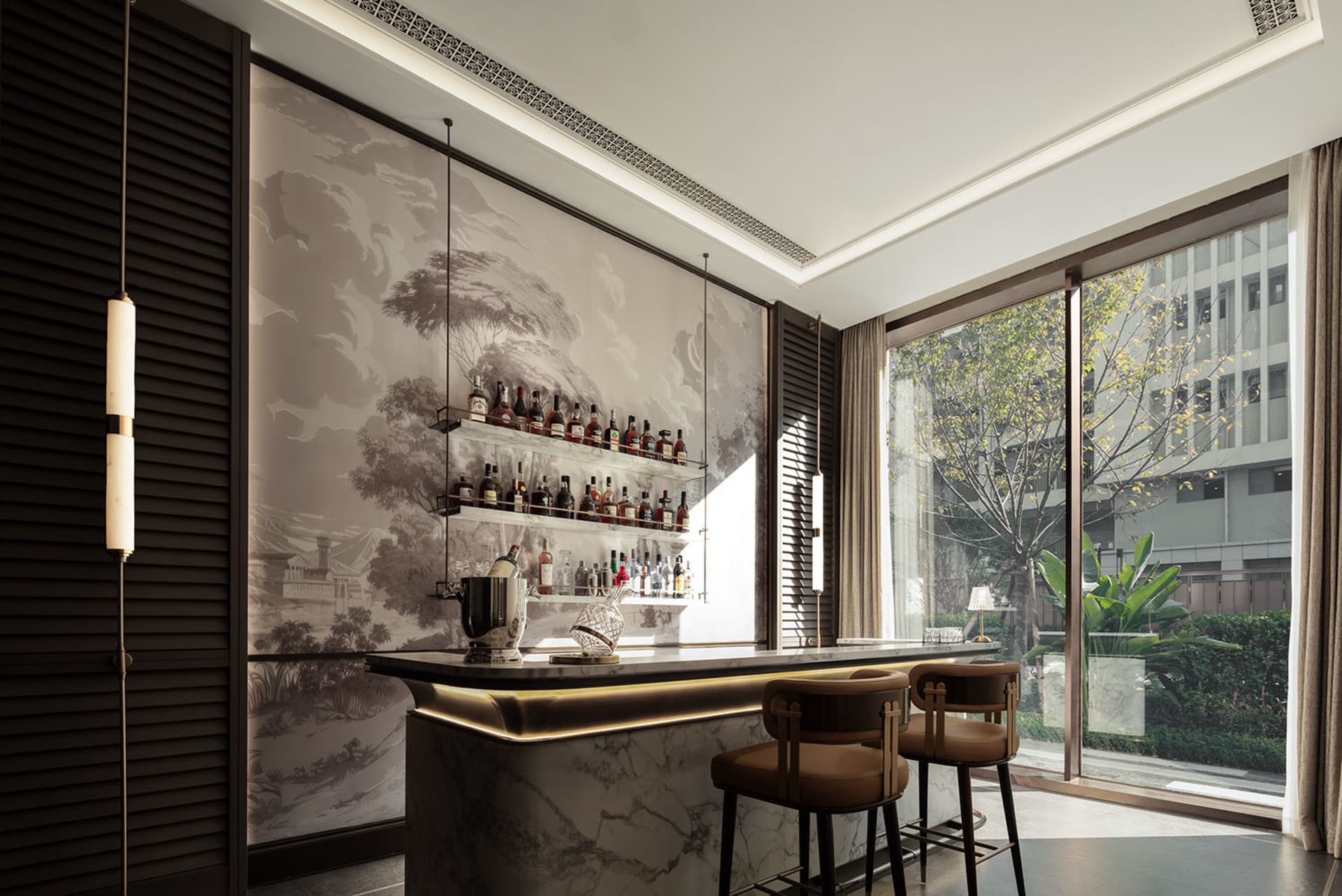 A modern bar with a marble counter, brown chairs, and a large collection of bottles, surrounded by a potted plant in a well-lit setting