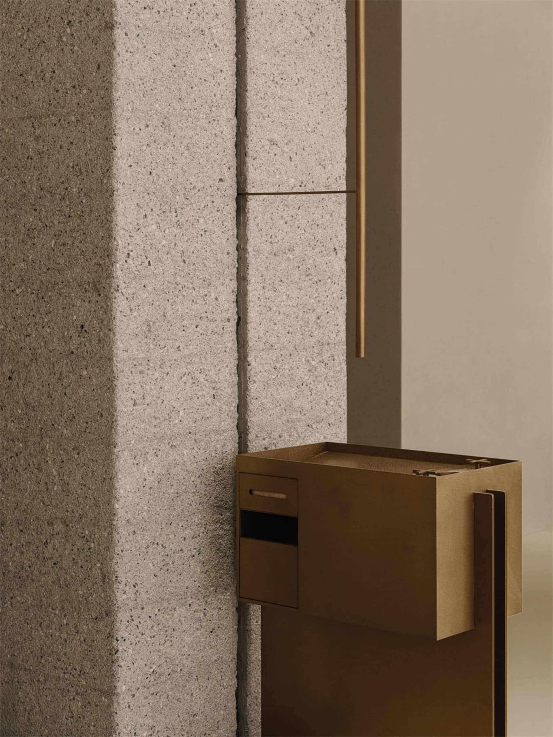 Cozy room with a large stone wall, wooden accents, and a brown box on the floor, lit by dim lighting