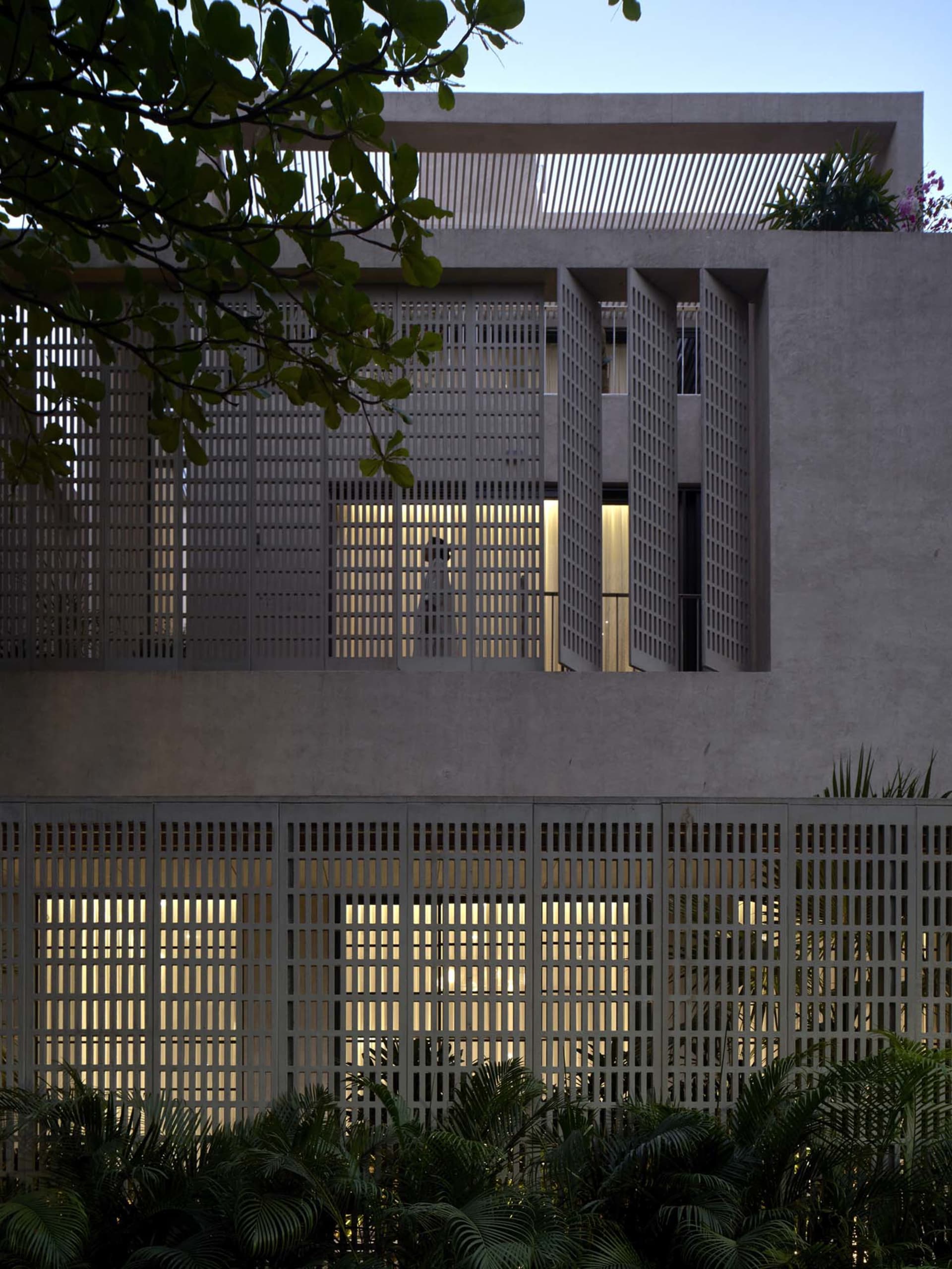 Photograph of a modern building with a concrete exterior, large window, and natural light