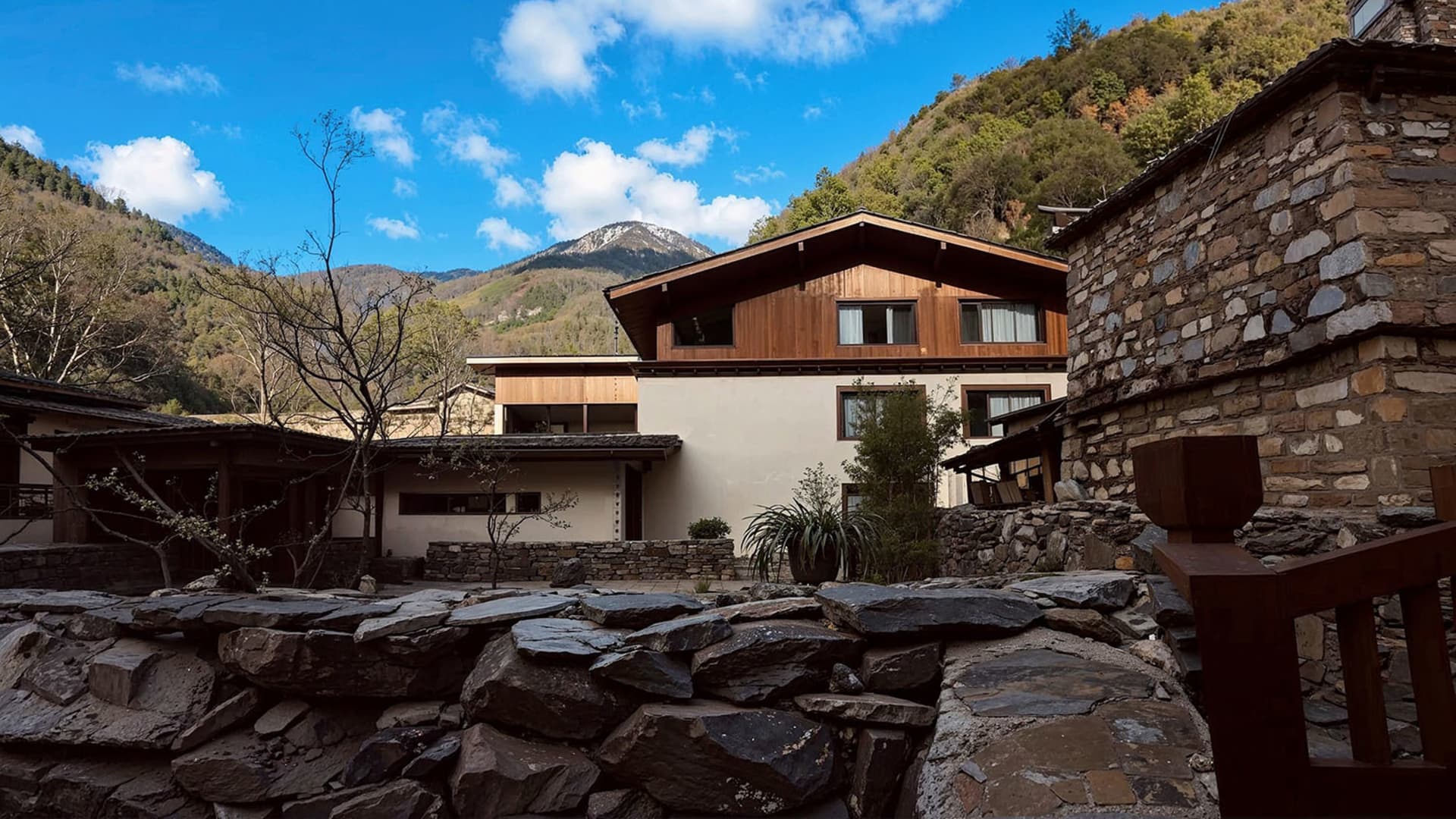 一座兩層小屋的照片，石牆、木屋頂、透過窗戶流入的自然光線
