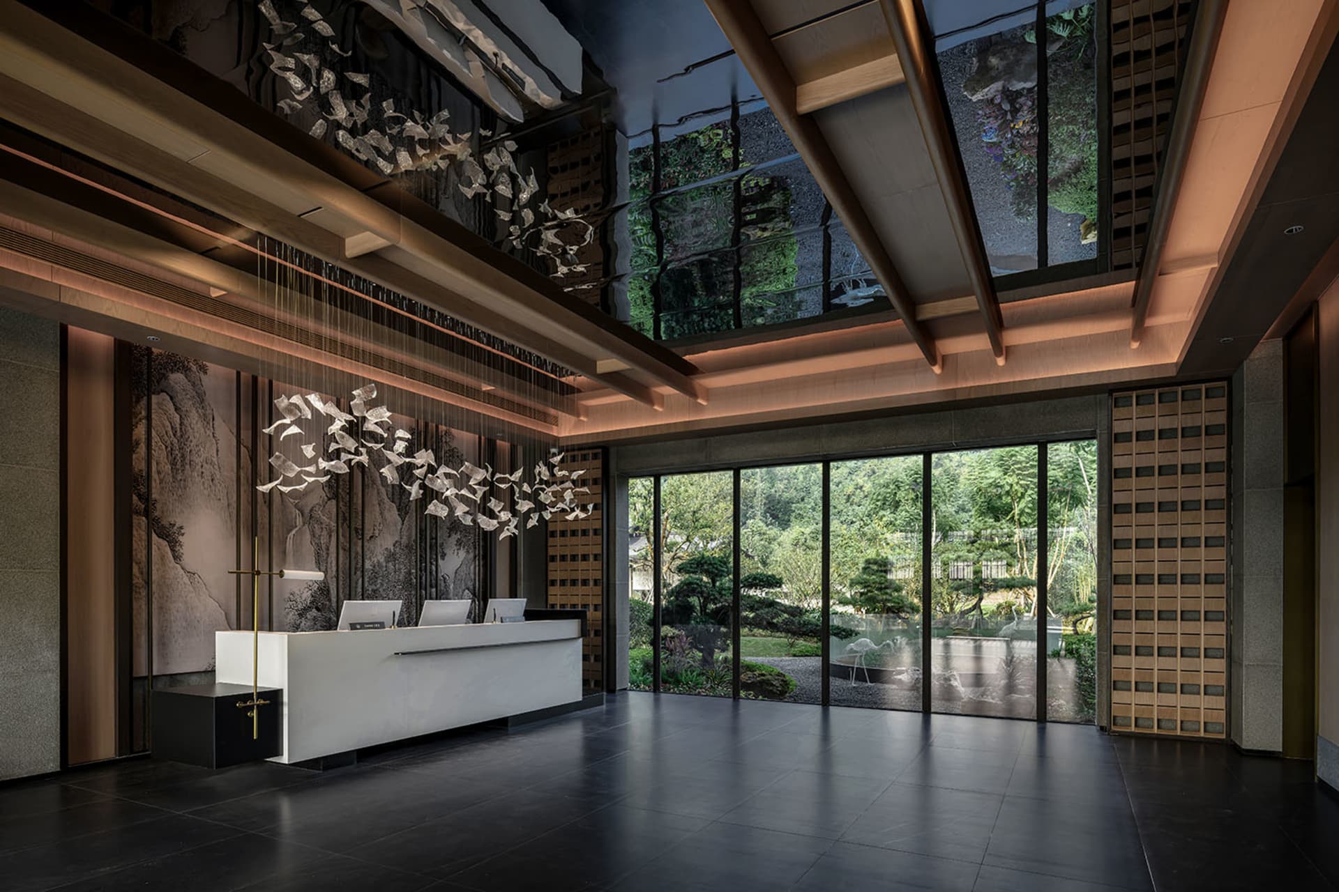 Modern lobby with a white desk, counter, and large window allowing natural light to enter, decorated with wood and glass materials