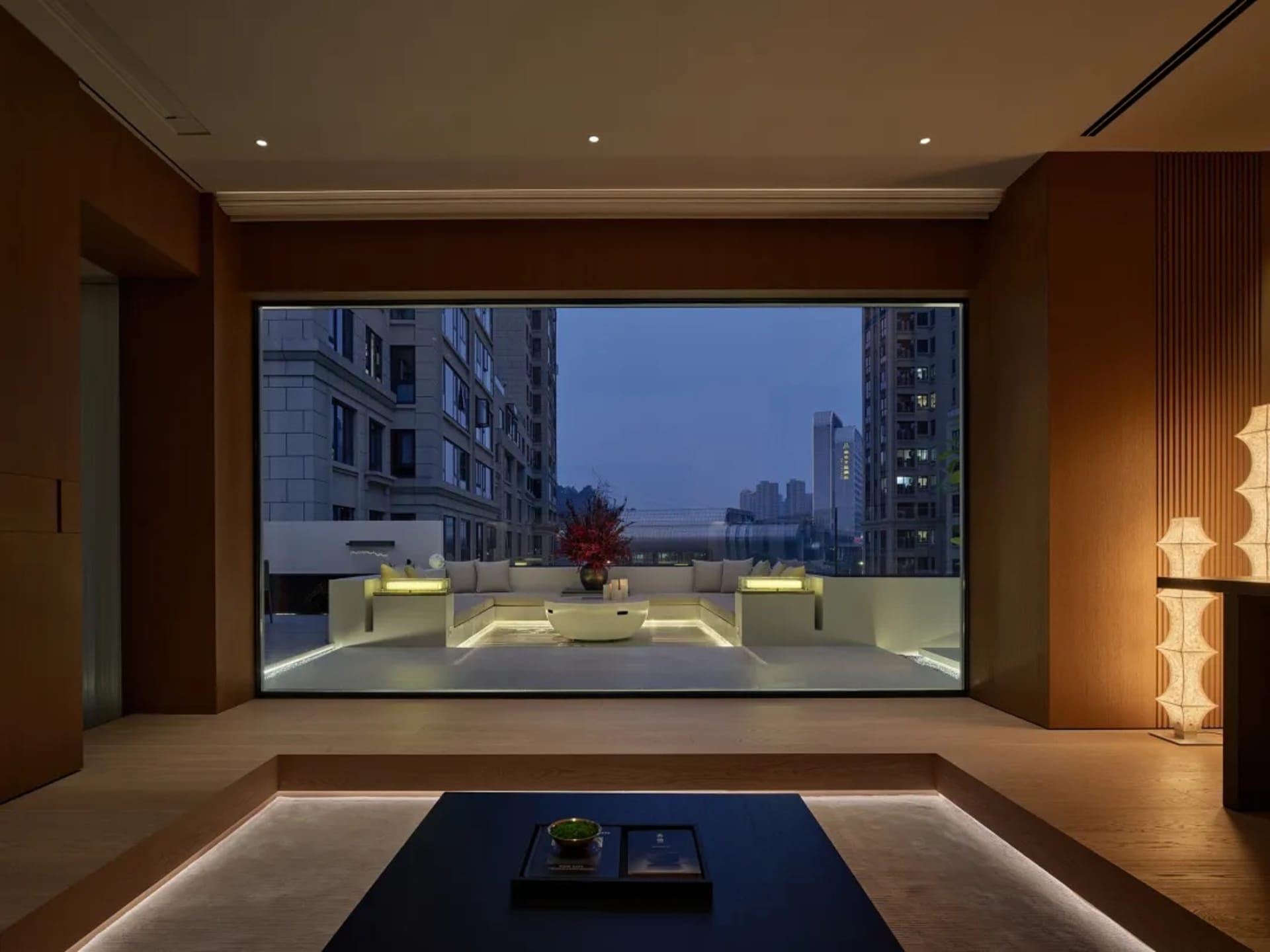 一間充滿光明的客廳，擁有沙發、椅子和餐桌，使用木材和玻璃，呈現現代風格