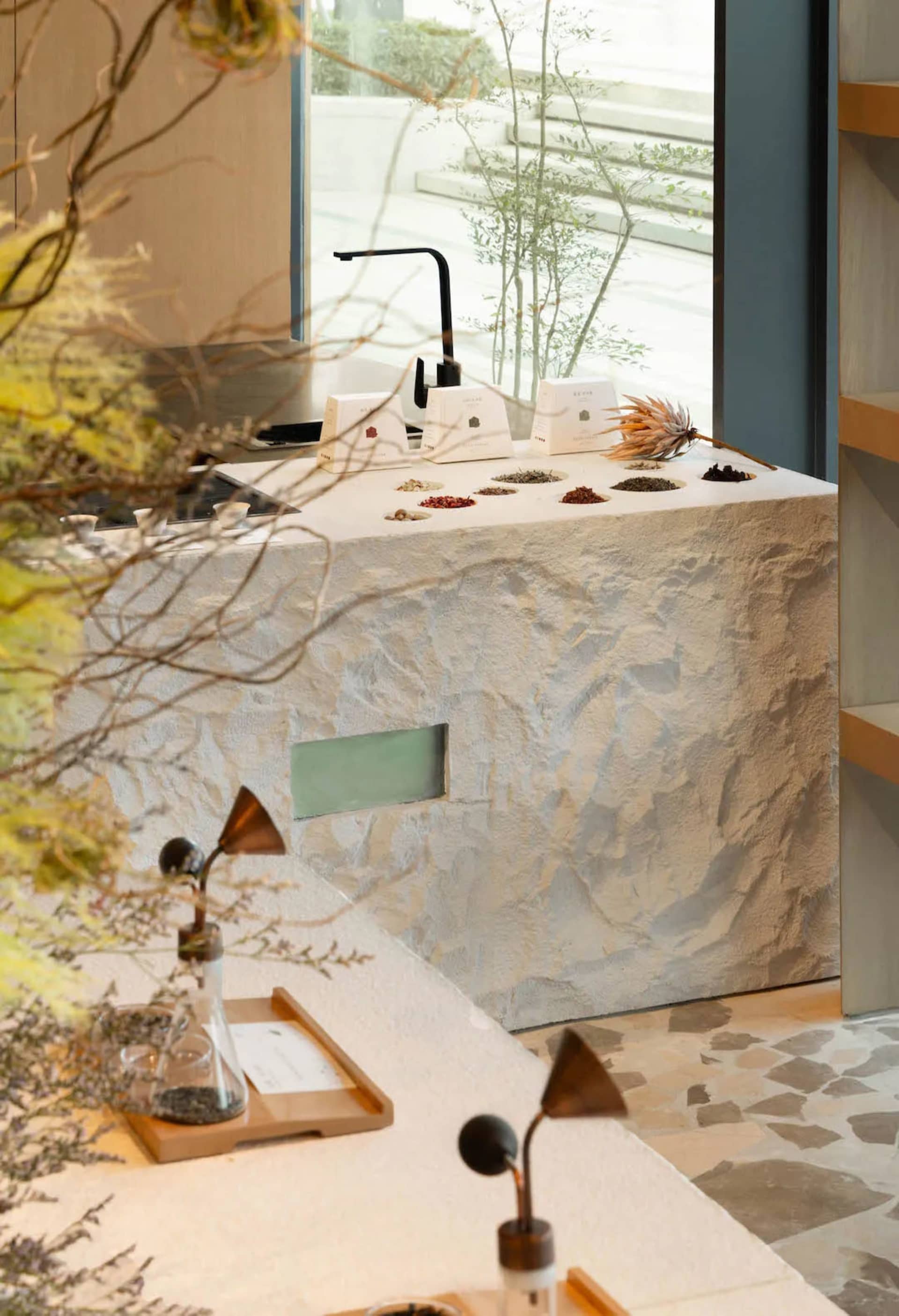 Bathroom with stone countertop and walls, sink, and toilet, dim lighting creating a cozy atmosphere
