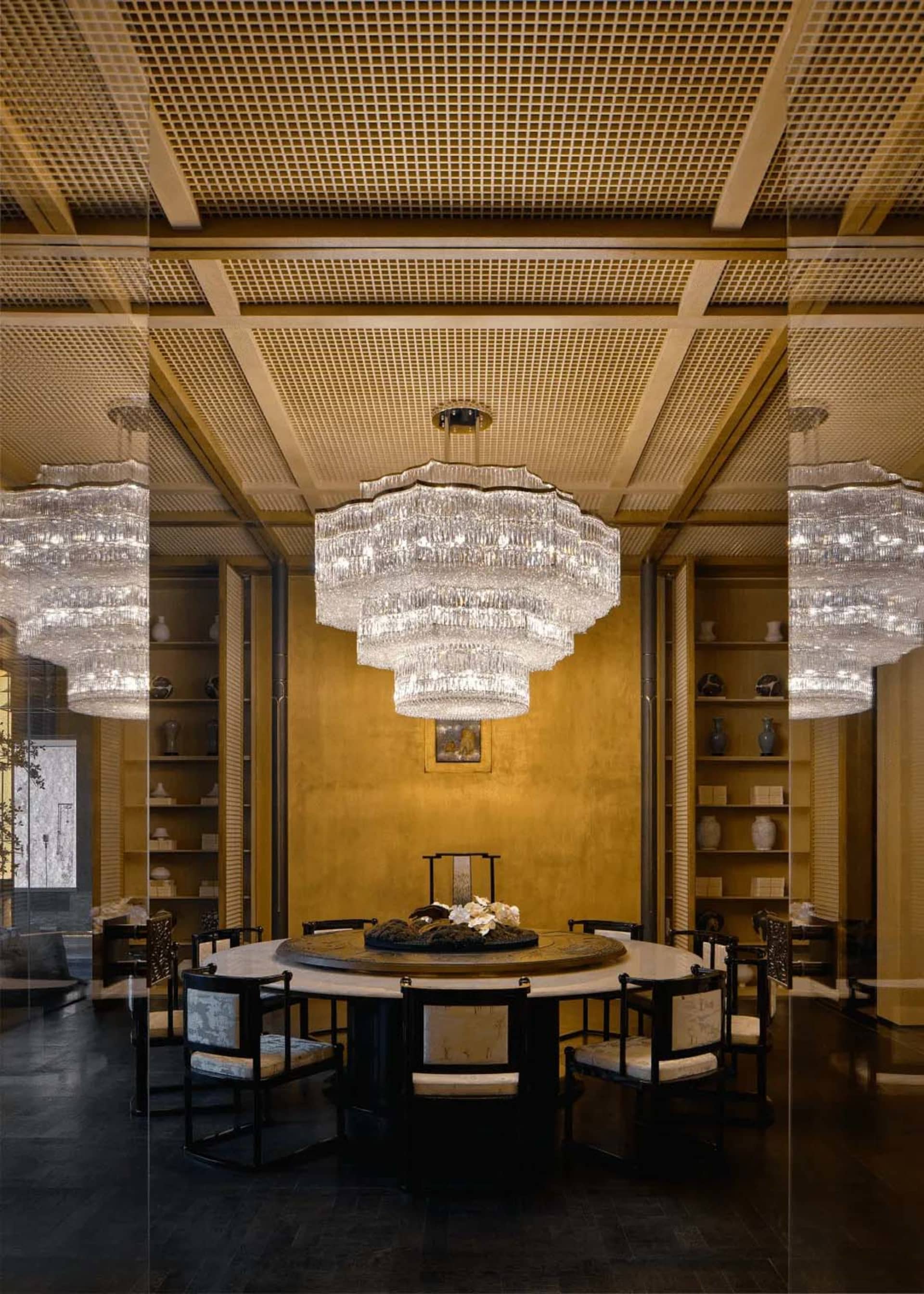 Formal dining room with a gold and white color scheme, a large dining table, and elegant vases