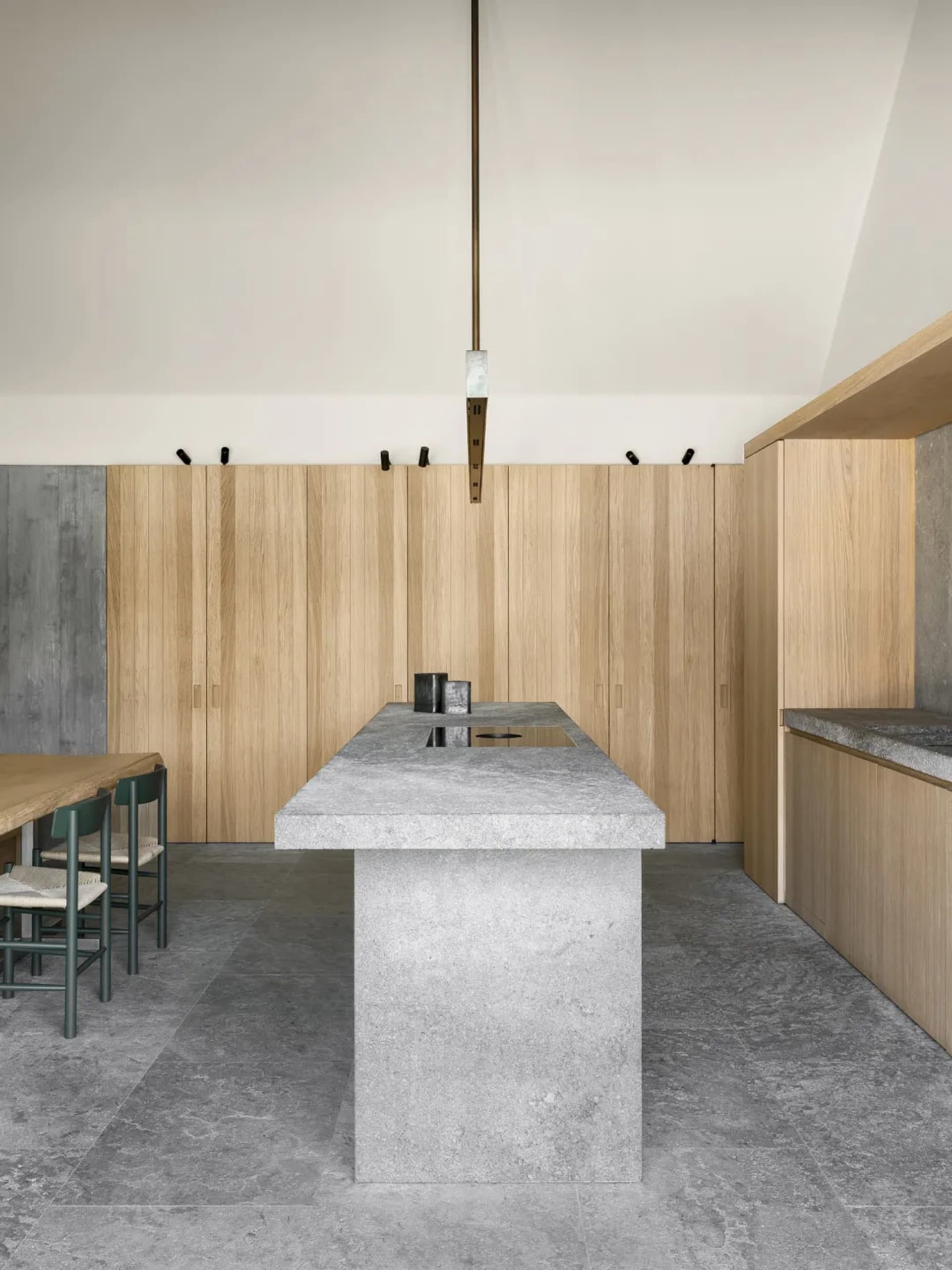 Modern kitchen with wooden cabinets, marble countertop, and natural light from windows