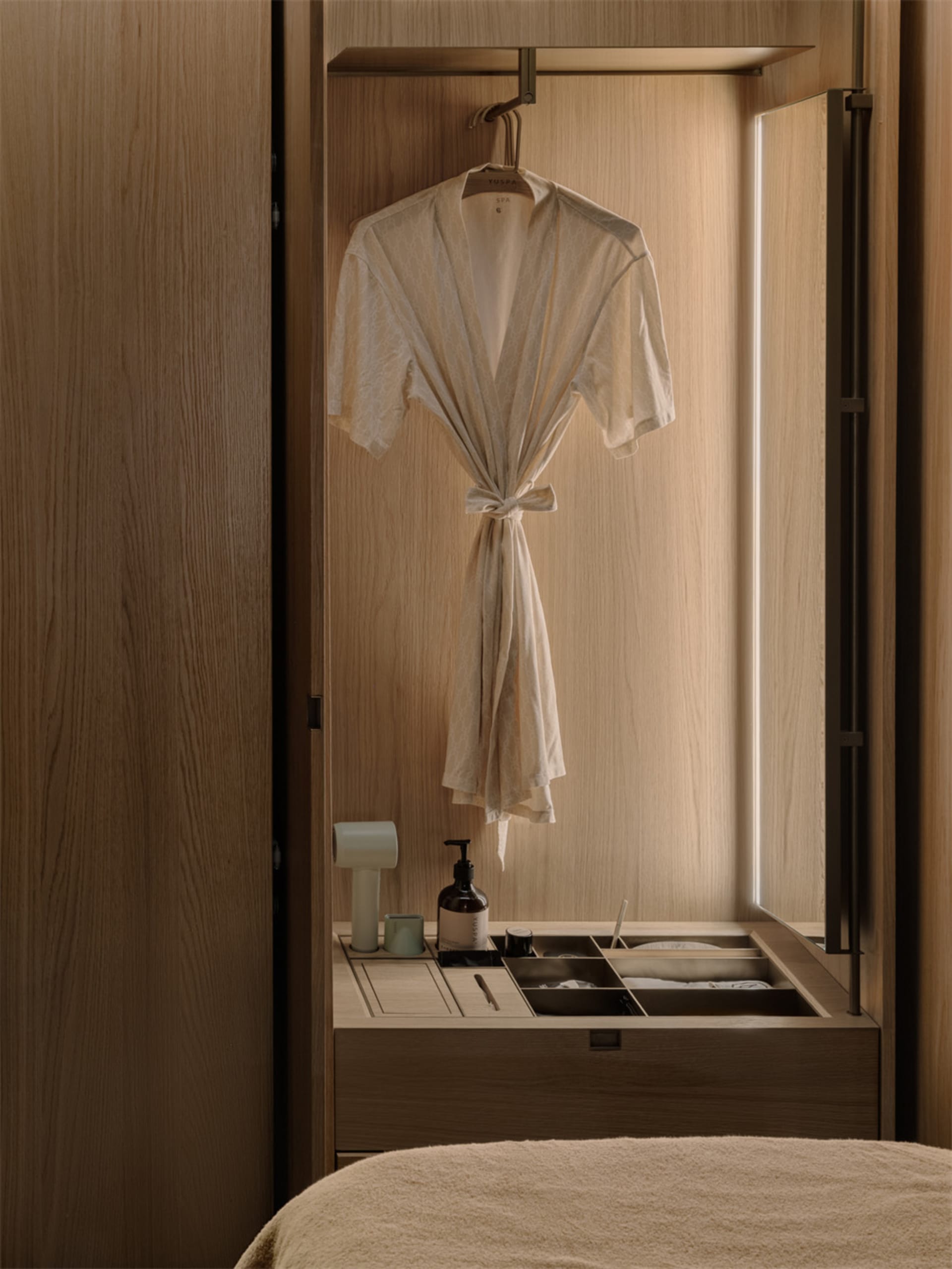 Bathroom with a wooden cabinet, white robe, and natural ambiance