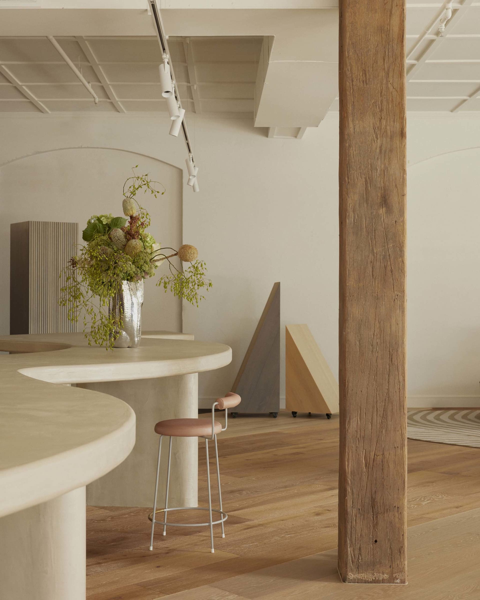 Cozy living and dining area with a wooden floor, a bar, a dining table, and a potted plant