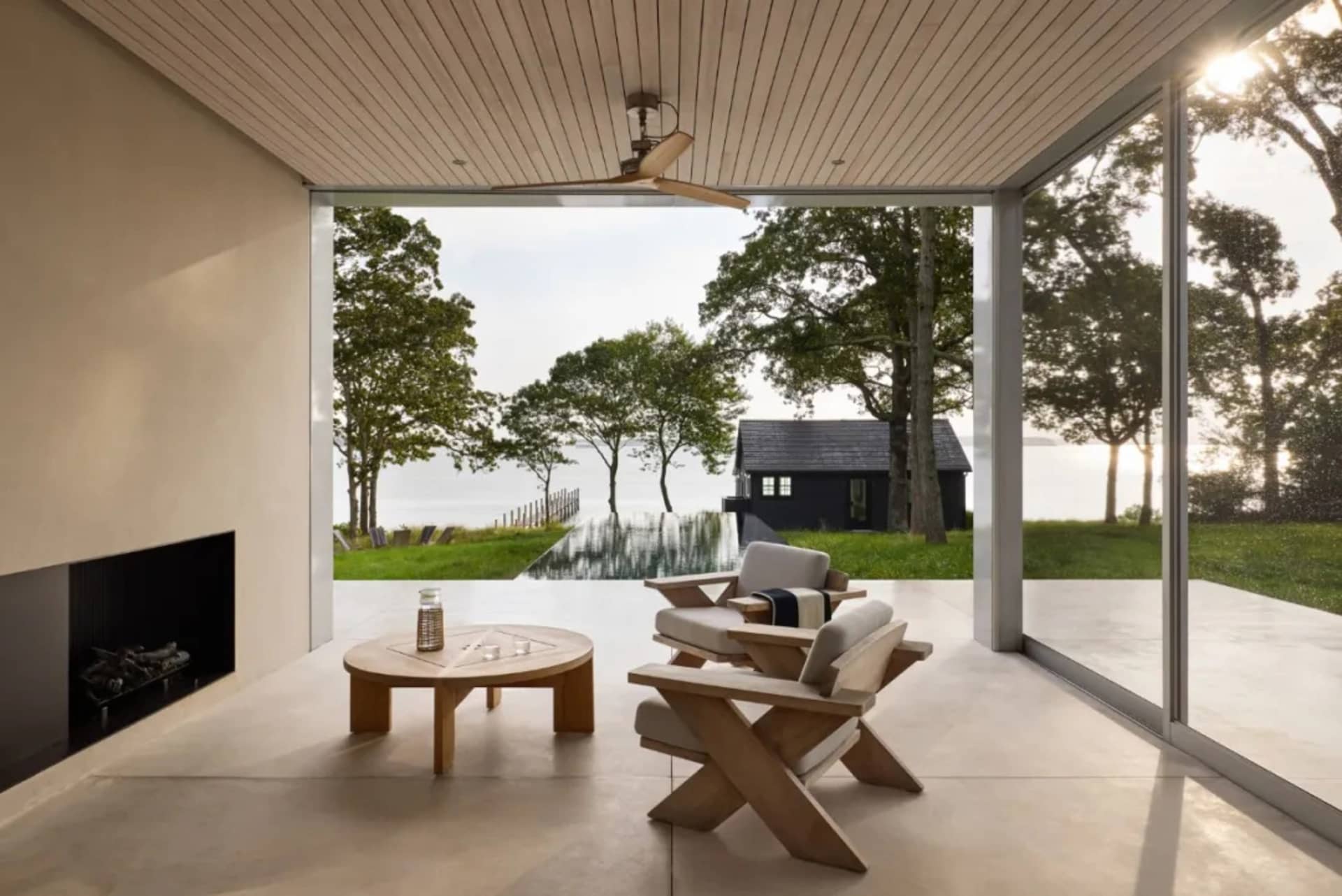 A backyard patio with a round wooden table and chairs, surrounded by natural and artificial materials, with warm sunlight and a relaxed atmosphere