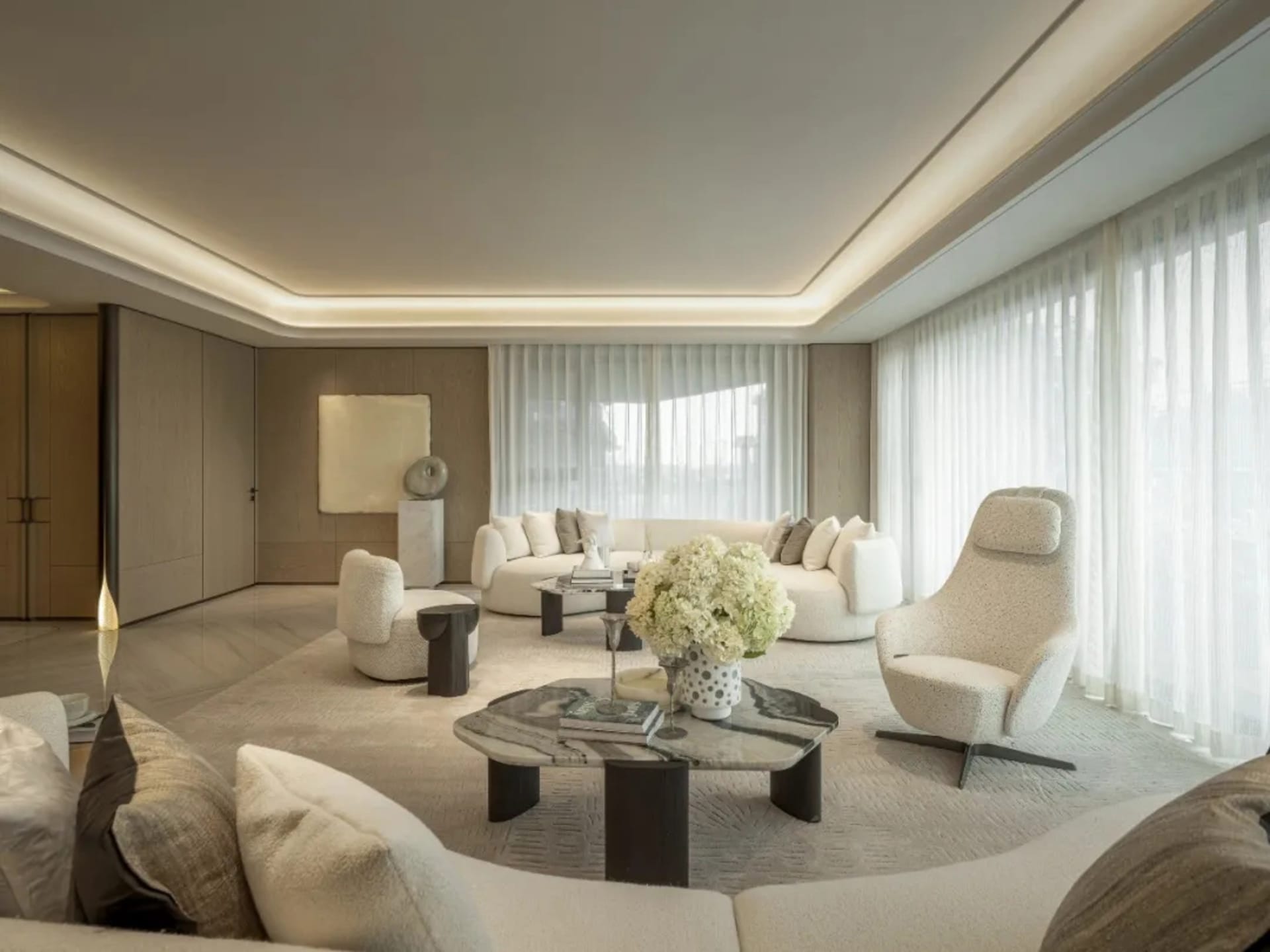 A modern living room with a glass window, natural light, and a variety of seating options, including couches, chairs, and a bench, with a dining table and a vase of flowers