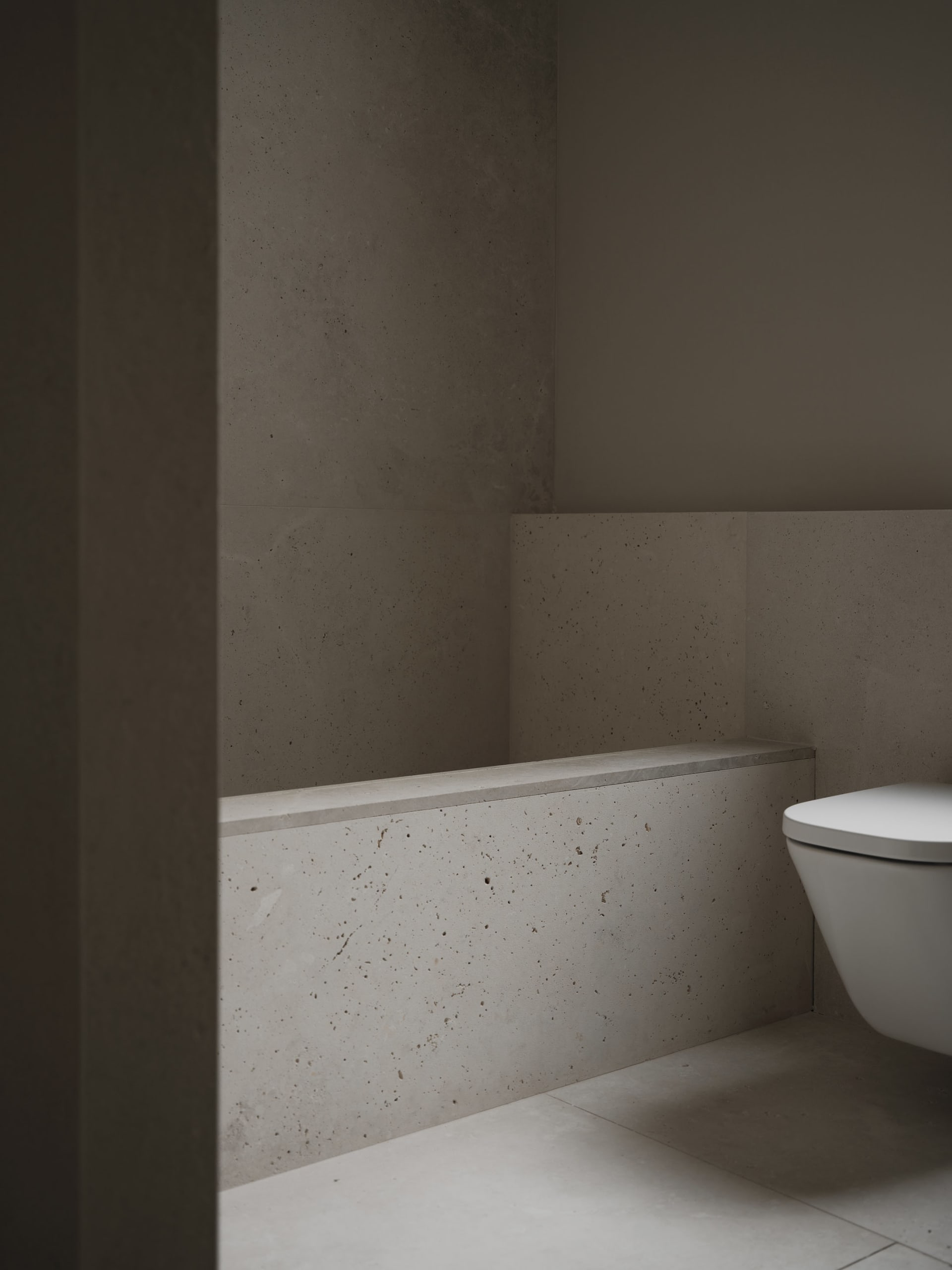 A modern bathroom with a white toilet and sink, marble walls, and a bright atmosphere