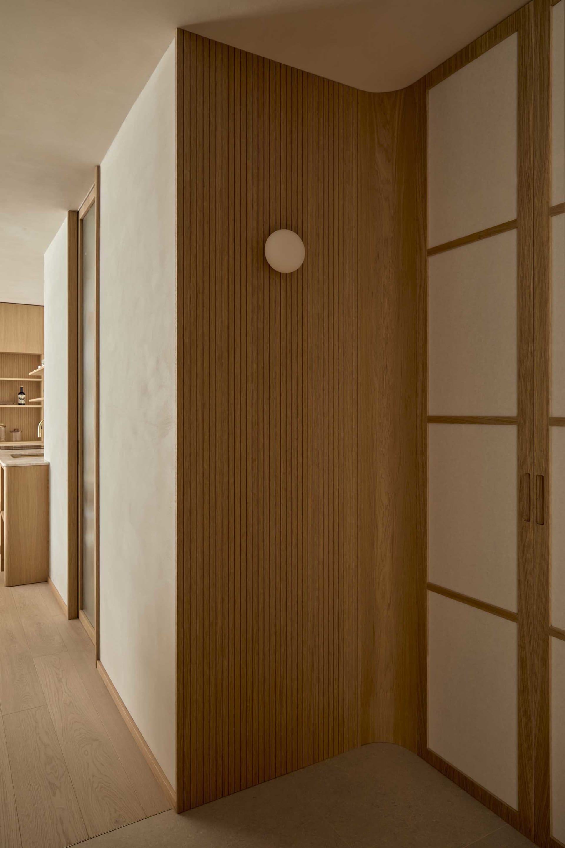 Cozy kitchen with wooden walls and floors, dim lighting, and a sink visible
