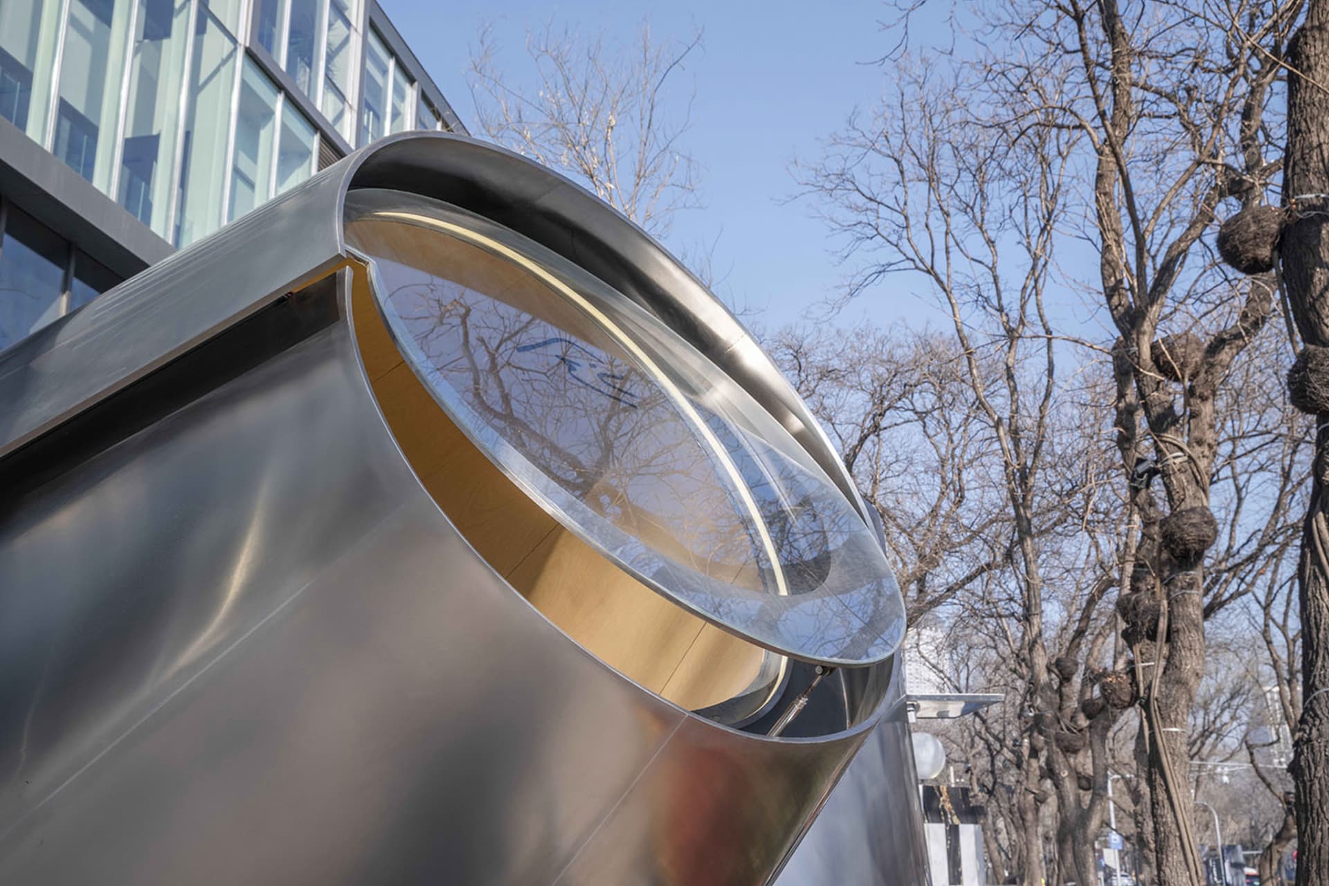A modern building with a large metallic dome in the foreground, surrounded by reflective glass surfaces and a sophisticated atmosphere