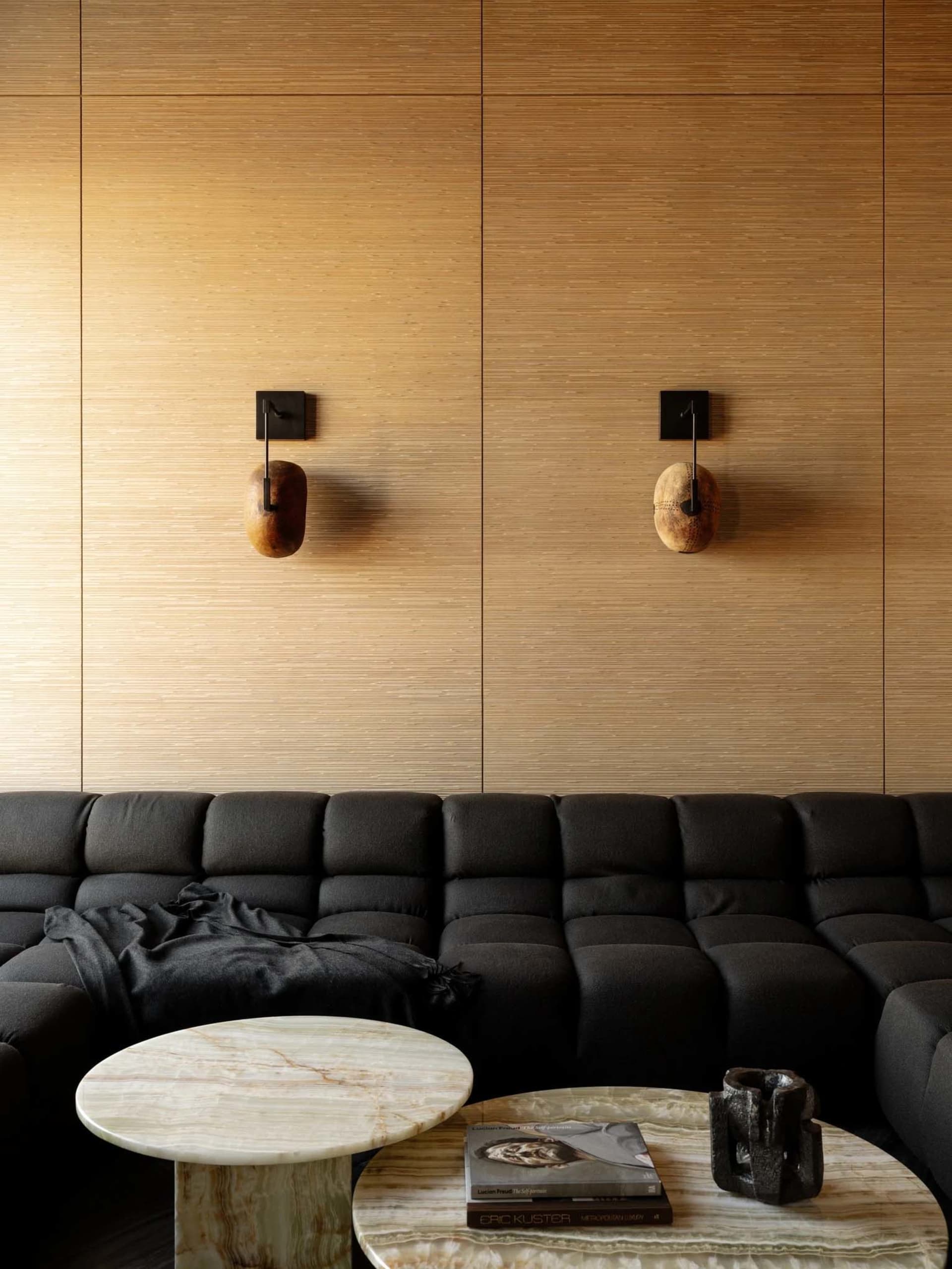 A modern living room with a wooden wall, a wooden table, and a comfortable atmosphere created by well-placed lighting