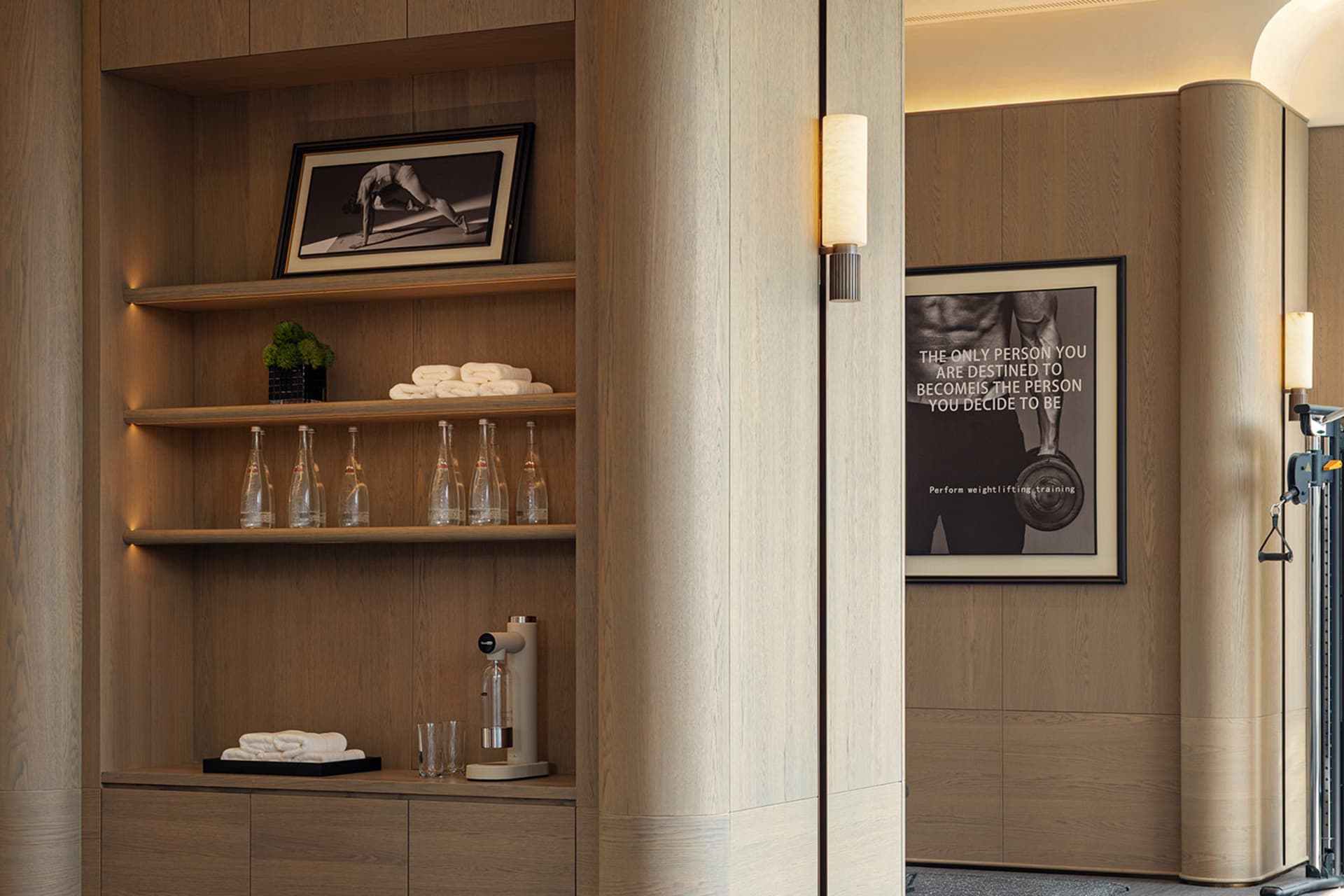 Cozy room with wooden walls and floors, featuring a wooden cabinet with a mirror and a picture, bottles, and a potted plant, in a dimly lit space with a mix of modern and traditional elements