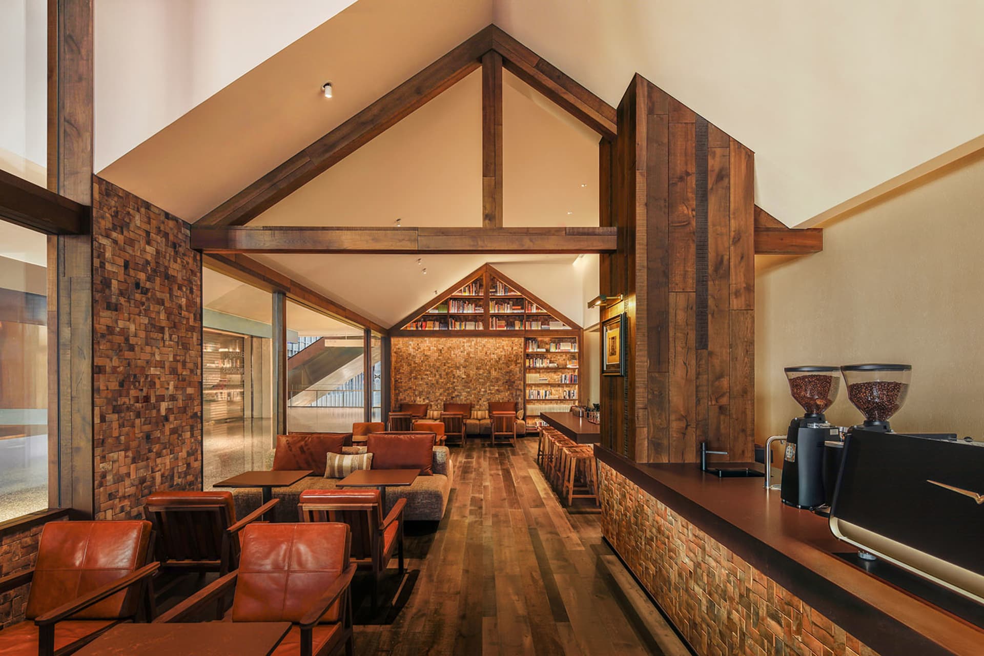 Warm and inviting living space with wooden walls and floor, natural light, and comfortable seating options